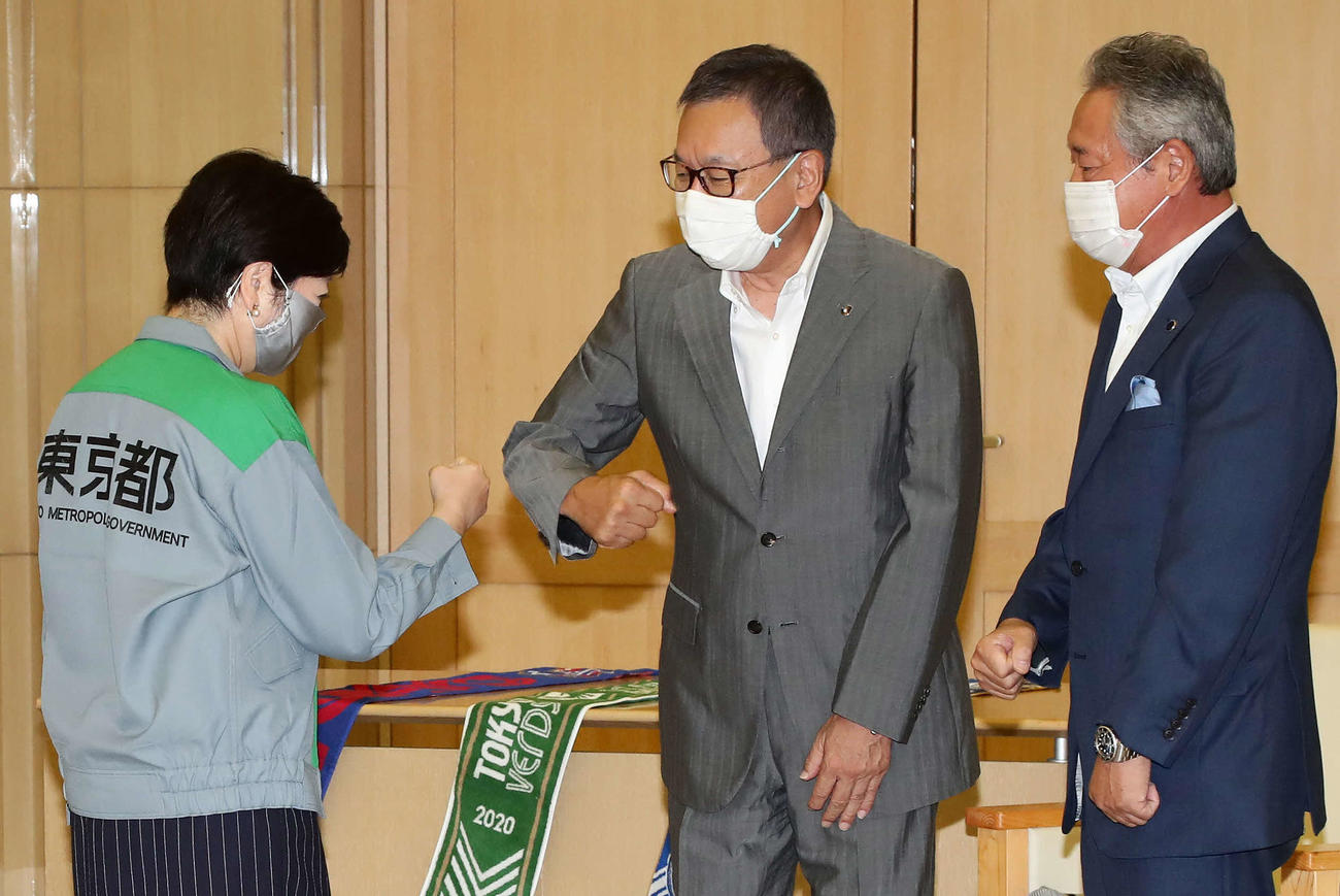 小池東京都知事（左）と拳を合わせる村井チェアマン（中央）。右は町田の下川会長（撮影・丹羽敏通）