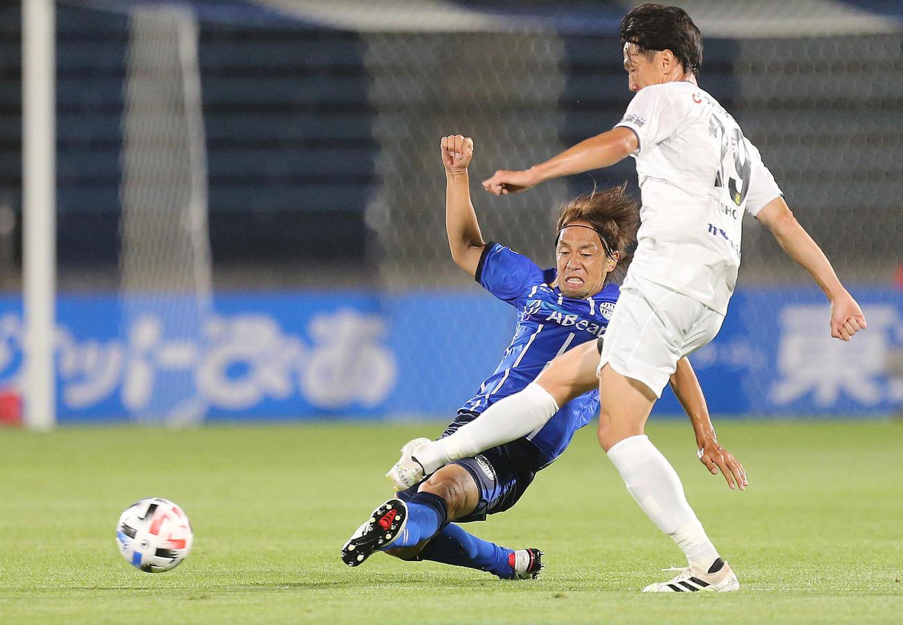 山形対栃木　前半、栃木FW矢野（右）にスライディングタックルする山形MF本田（撮影・野上伸悟）