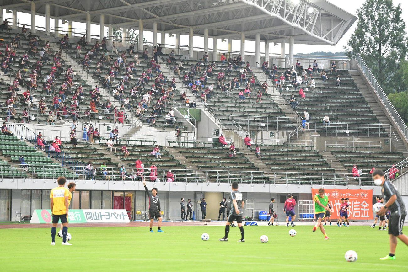 J2岡山対北九州　試合前、スタンドのサポーターが見守る前で練習を行う選手たち（撮影・岩下翔太）