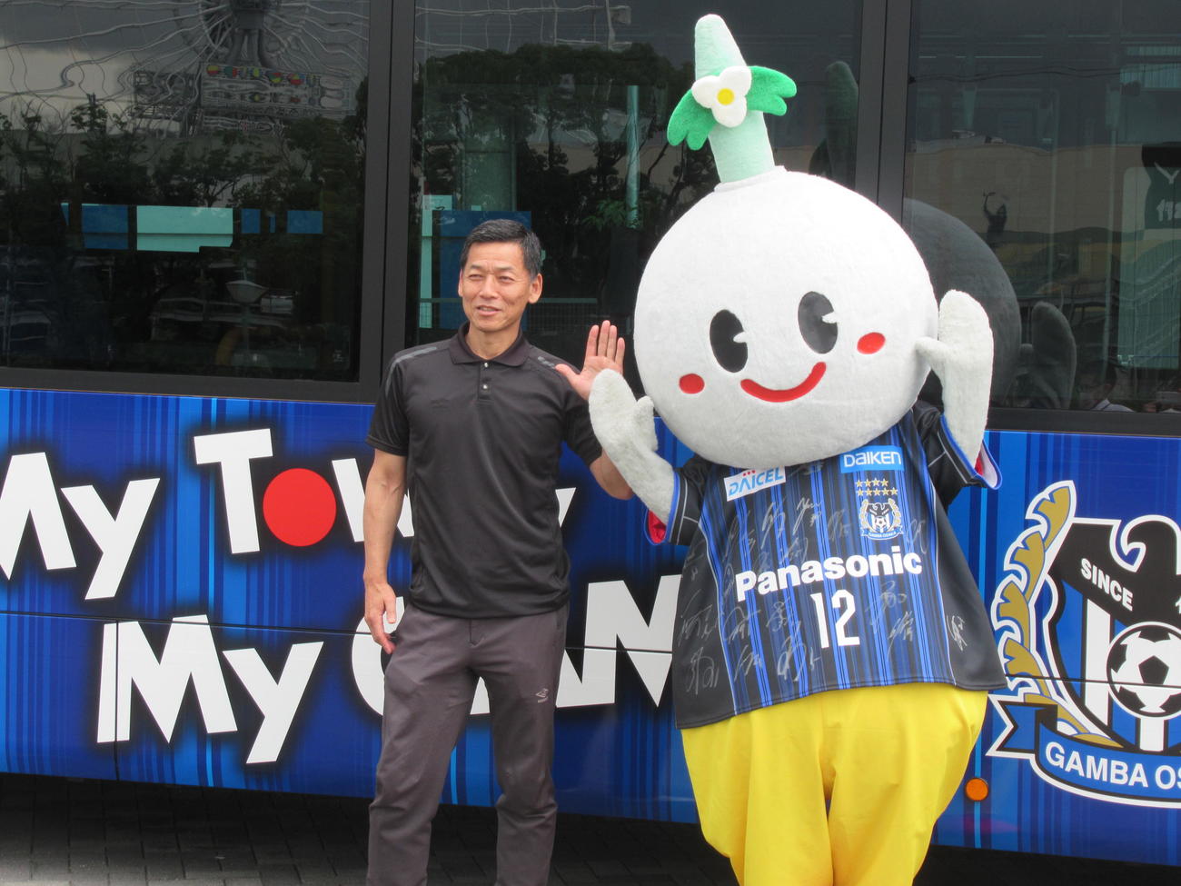 阪急バスの特別車両の前でG大阪小野社長（左）と大阪・吹田市のマスコット「すいたん」