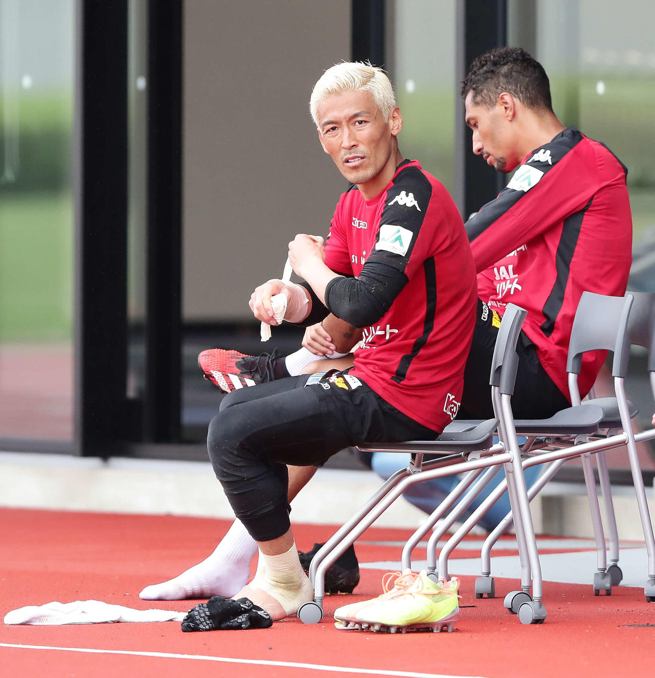 練習を終えてテーピングを外す札幌GK菅野孝。奥はFWジェイ（撮影・丹羽敏通）