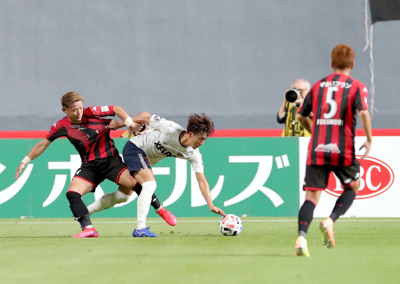 札幌対東京　東京DF中村のドリブルを阻止する札幌DF菅（左）（撮影・佐藤翔太）