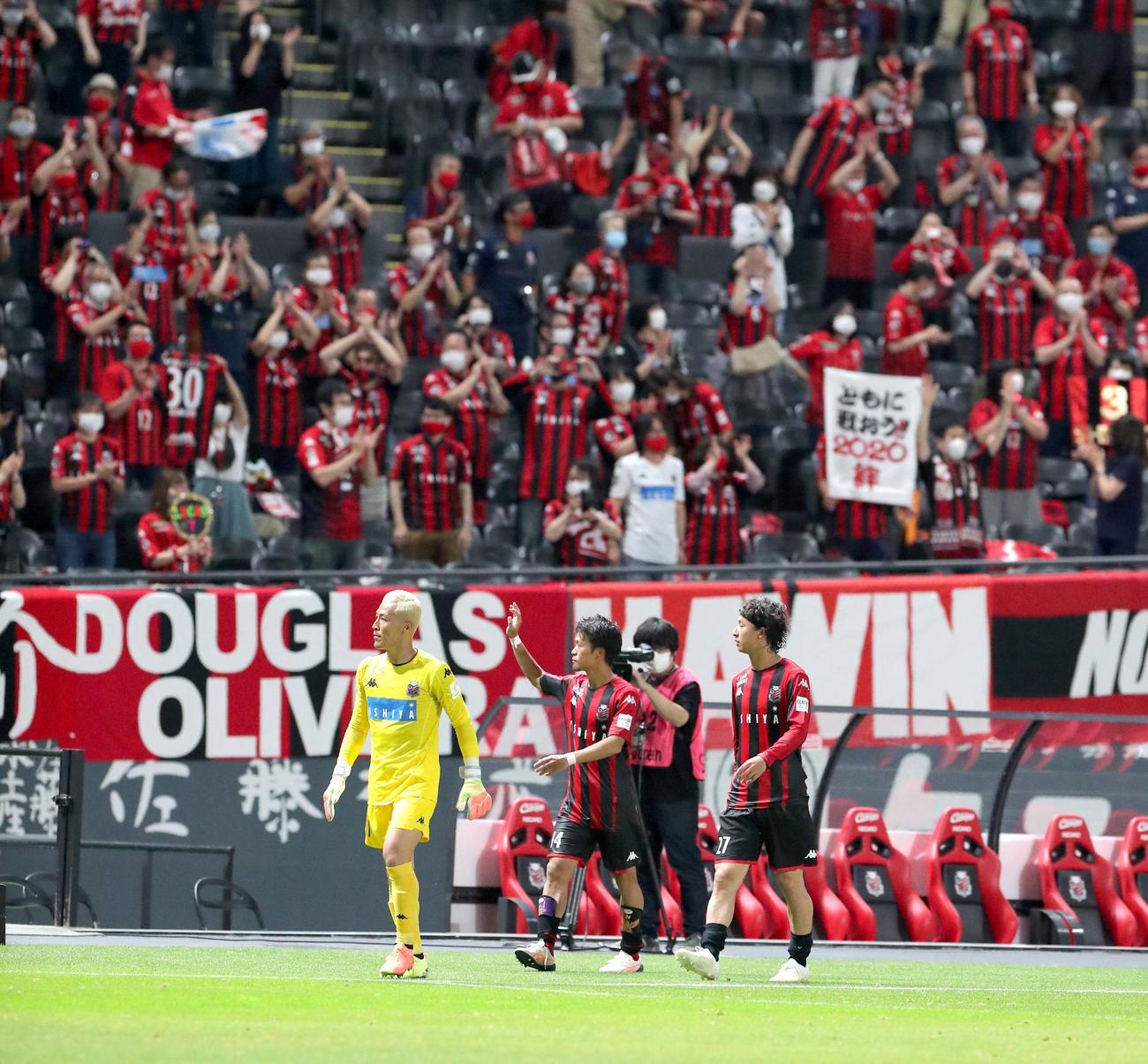 札幌対横浜　スタンド応援席のサポーターに手を振りながら引き揚げる左から札幌GK菅野、MF駒井、MF荒野（撮影・佐藤翔太）