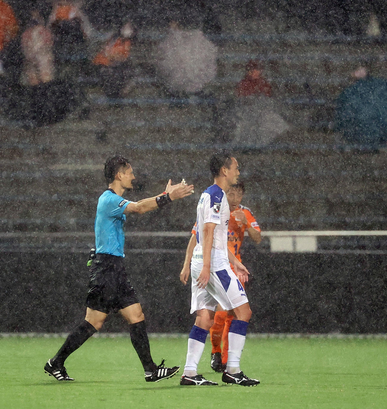 清水対大分　後半途中、雨足が強まり雷が鳴り出したため試合を中断し選手たちにロッカーに引き揚げるよう促す主審（撮影・垰建太）
