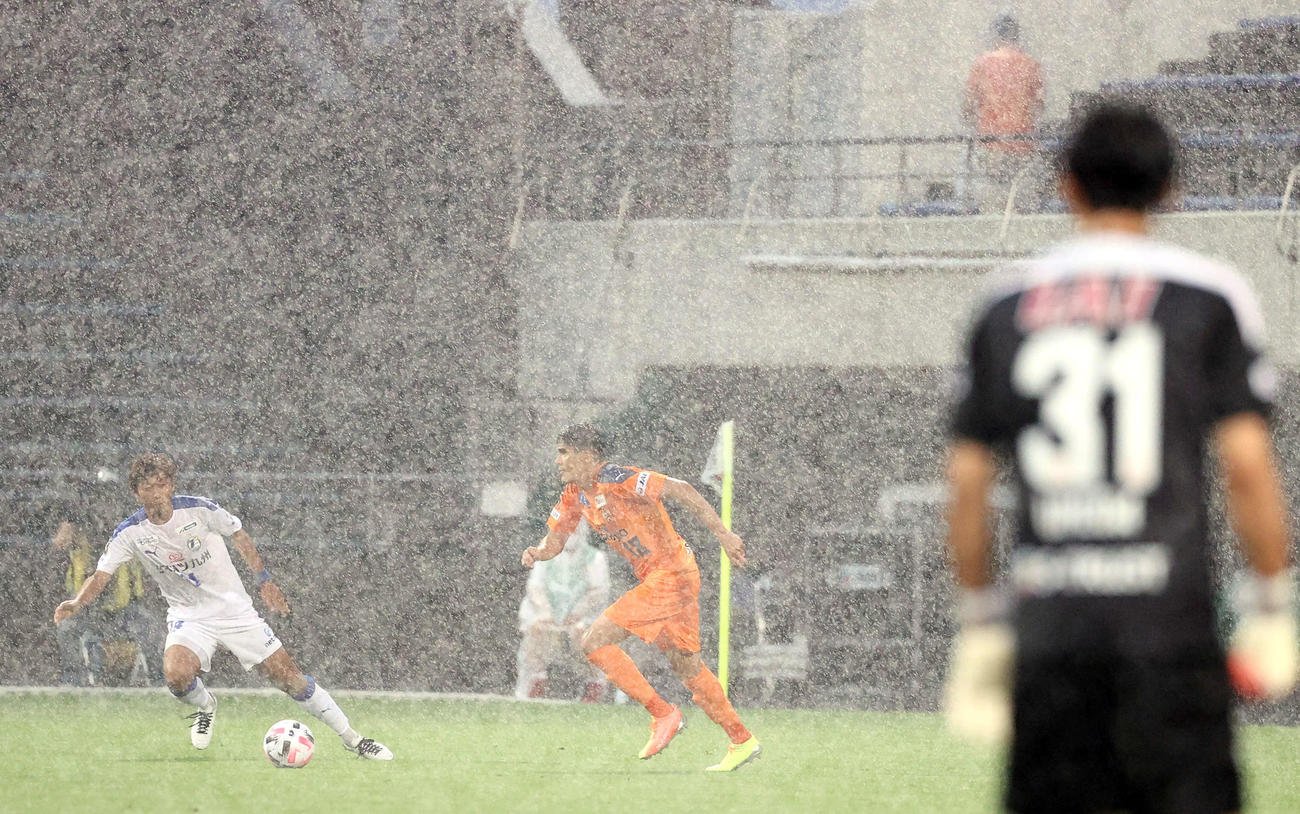 清水対大分　前半、突然降り出した豪雨の中プレーする清水DFエウシーニョ（中央）ら選手たち（撮影・垰建太）