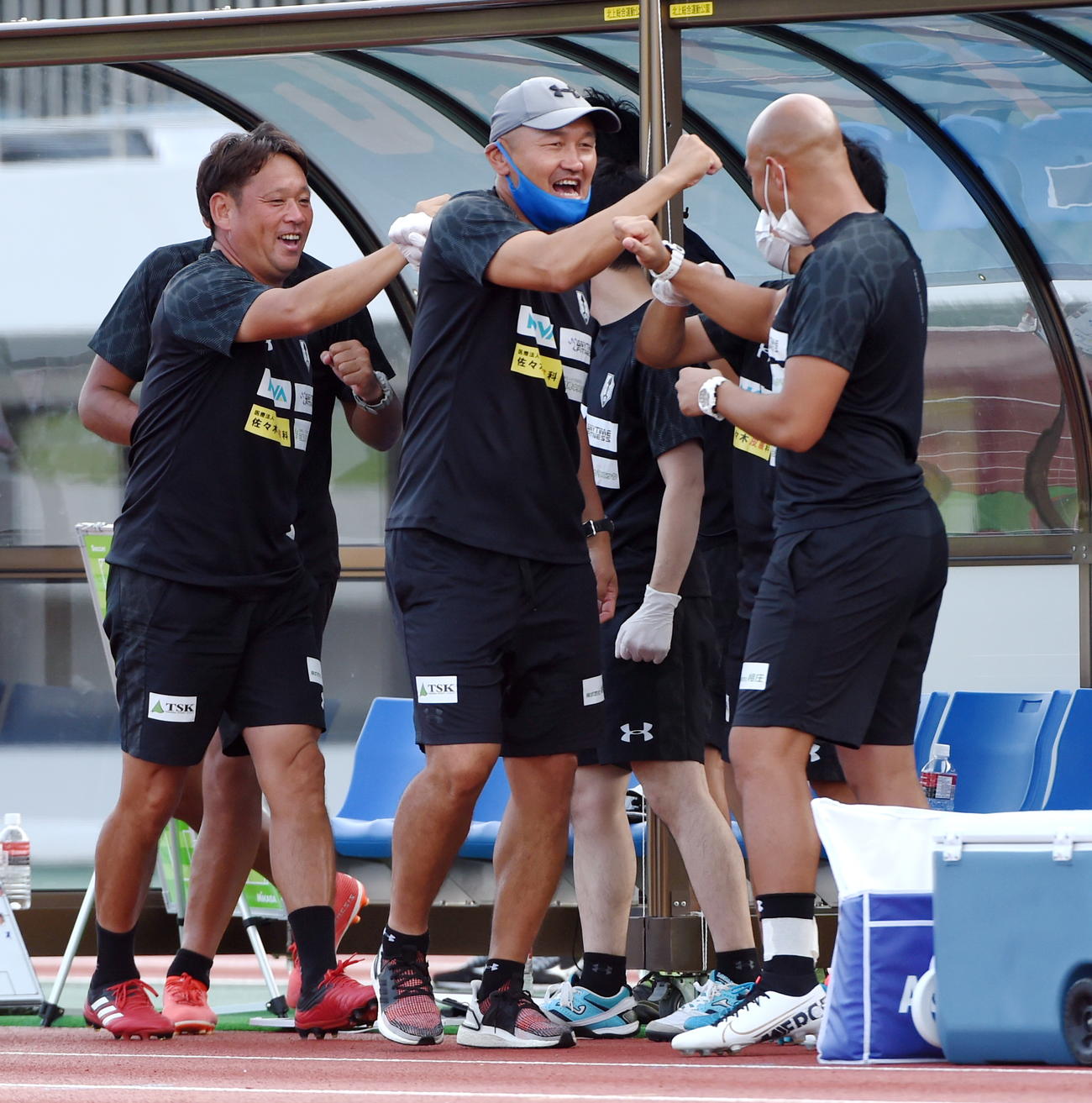 岩手対C大阪U－23　3連勝を飾りスタッフと笑顔で肘タッチする岩手・秋田監督（中央）（撮影・山田愛斗）