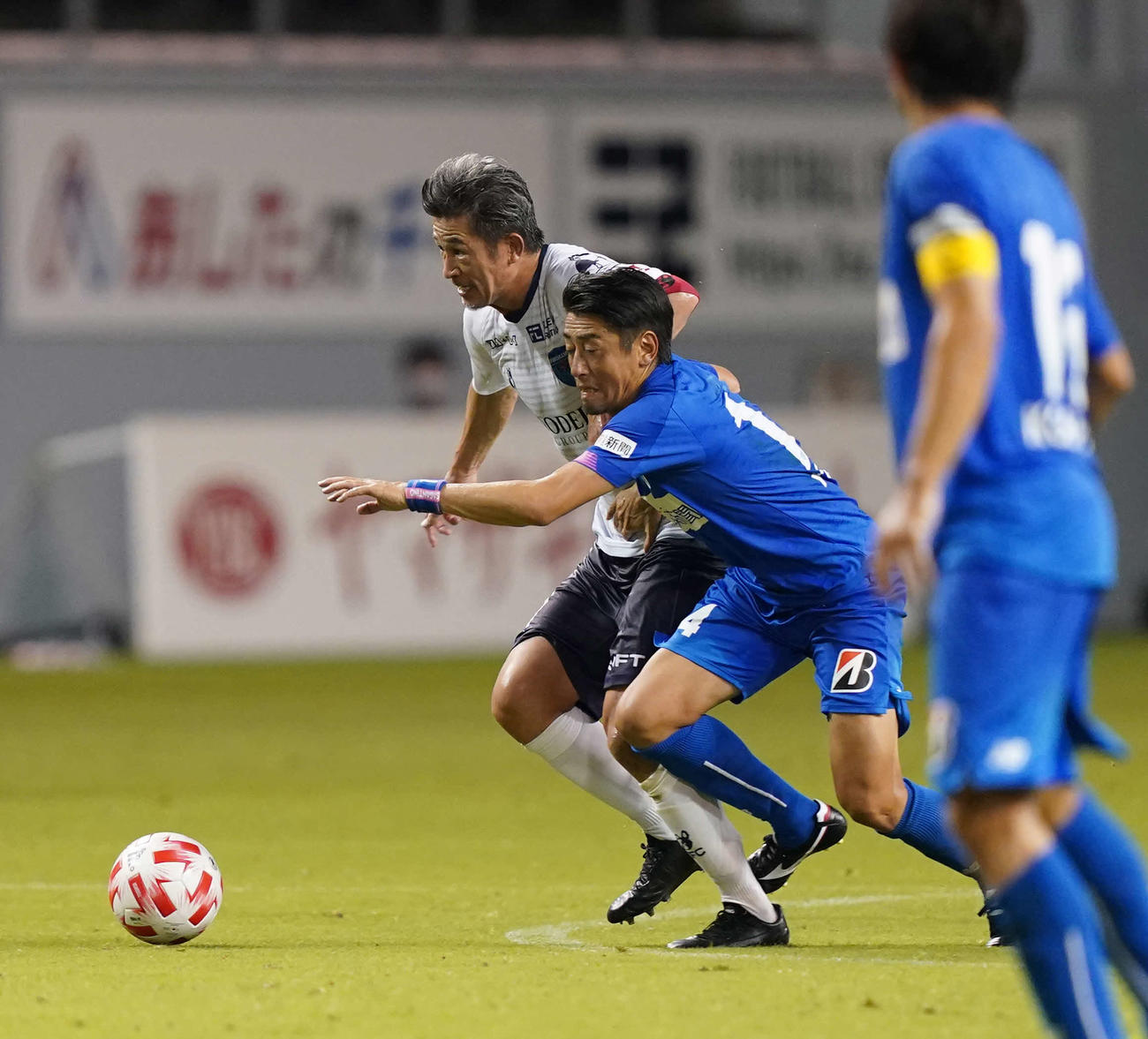 鳥栖対横浜FC　前半、鳥栖MF高橋義（右）と競り合う横浜FC・FWカズ（撮影・江口和貴）