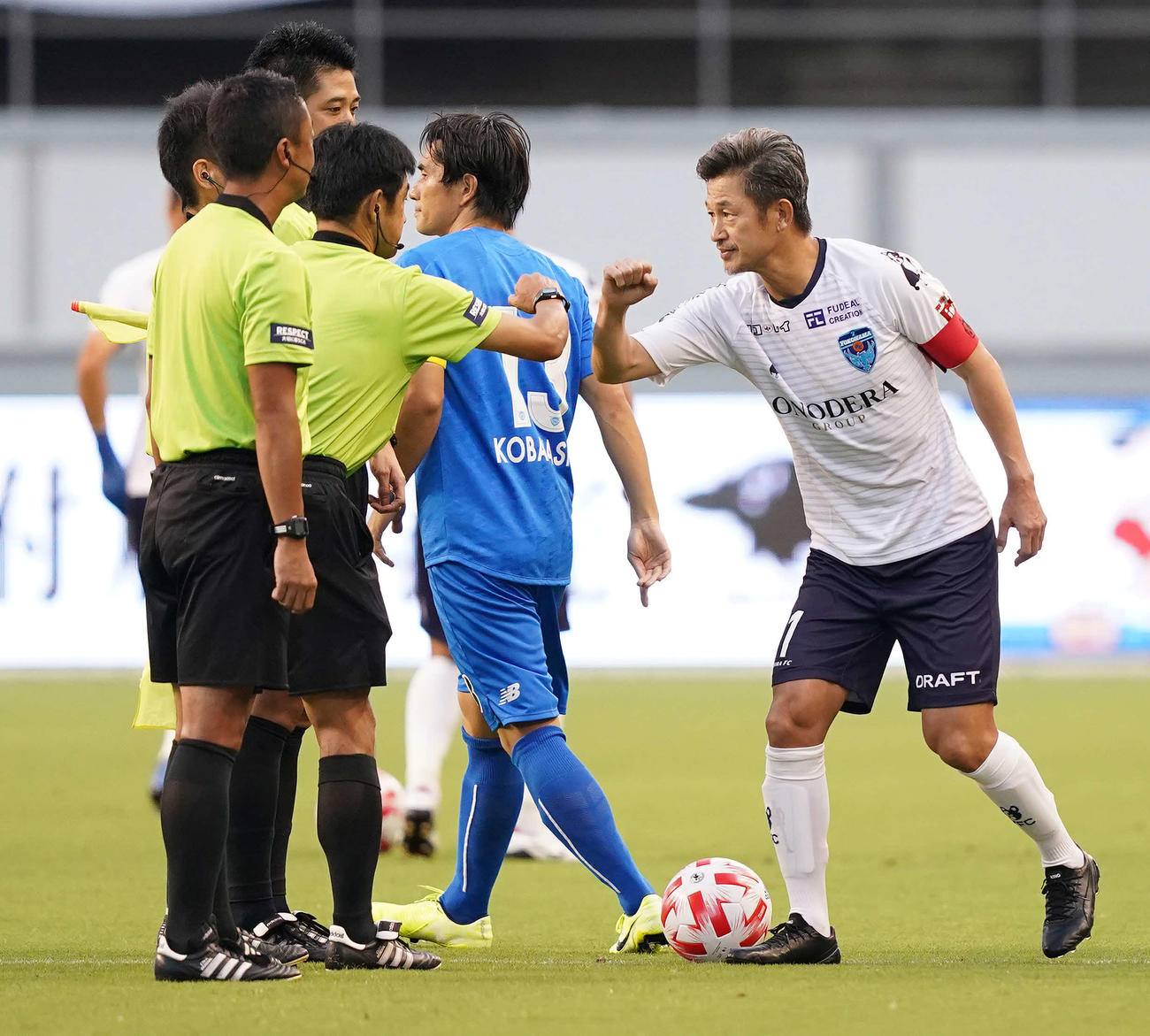 試合前、審判団と肘タッチをかわす横浜FC・FWカズ（撮影・江口和貴）