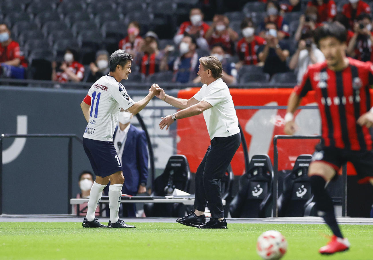 札幌―横浜FC　試合前、札幌・ペトロビッチ監督とタッチを交わす横浜FC・三浦（左）（共同）
