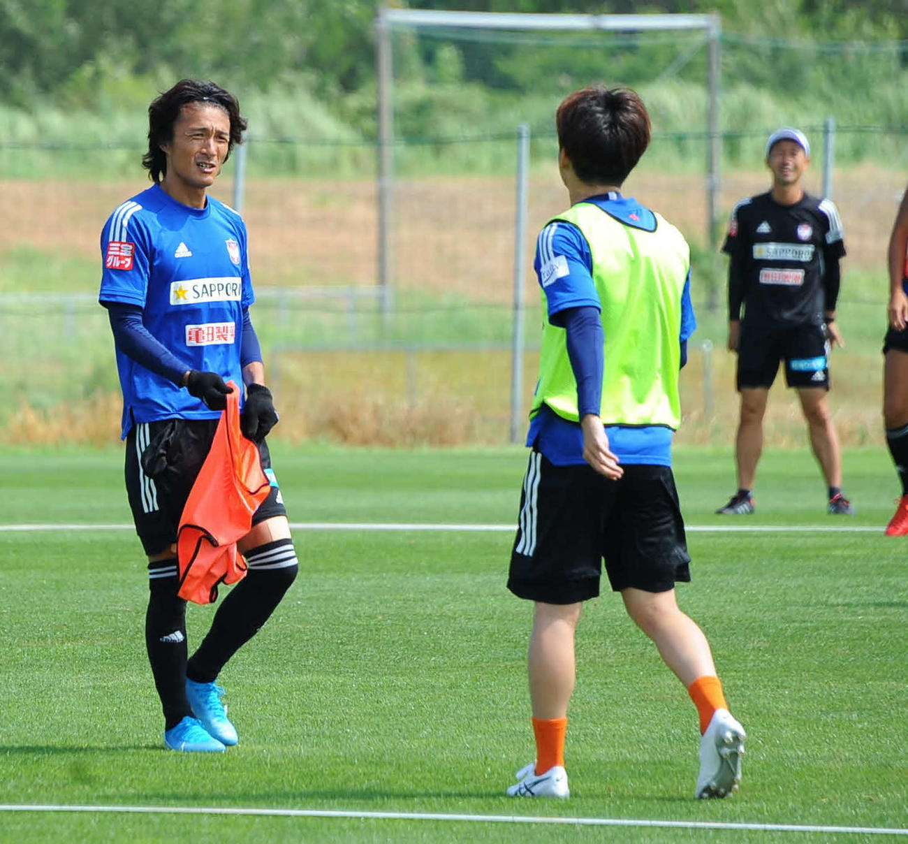 本間（右）と話しをする田中