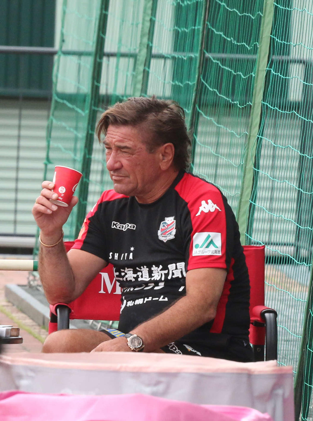 ドリンクを片手に練習を見つめる札幌ペトロビッチ監督（撮影・浅水友輝）
