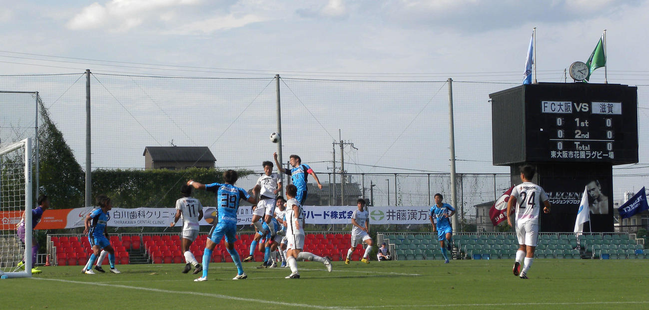 花園第2グラウンドで戦う青のユニホームのFC大阪とMIOびわこ滋賀の選手たち（撮影・松本航）