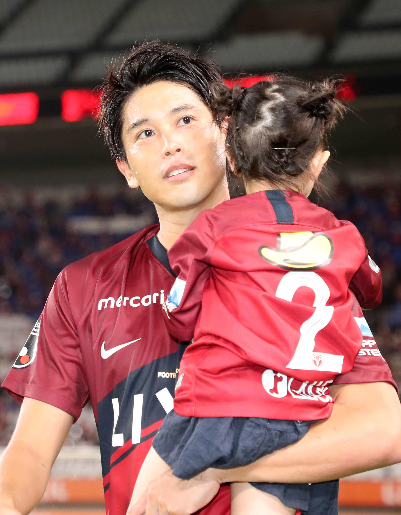 鹿島対G大阪　長女を抱っこしサポーターにあいさつに向かう鹿島DF内田（撮影・鈴木正人）