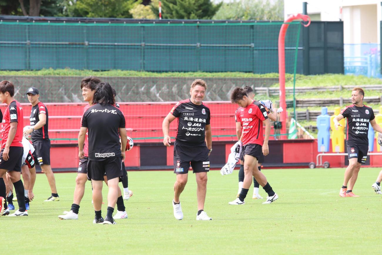 横浜戦前日練習を終え、笑顔でピッチを移動する札幌ペトロビッチ監督（中央）（撮影・保坂果那）
