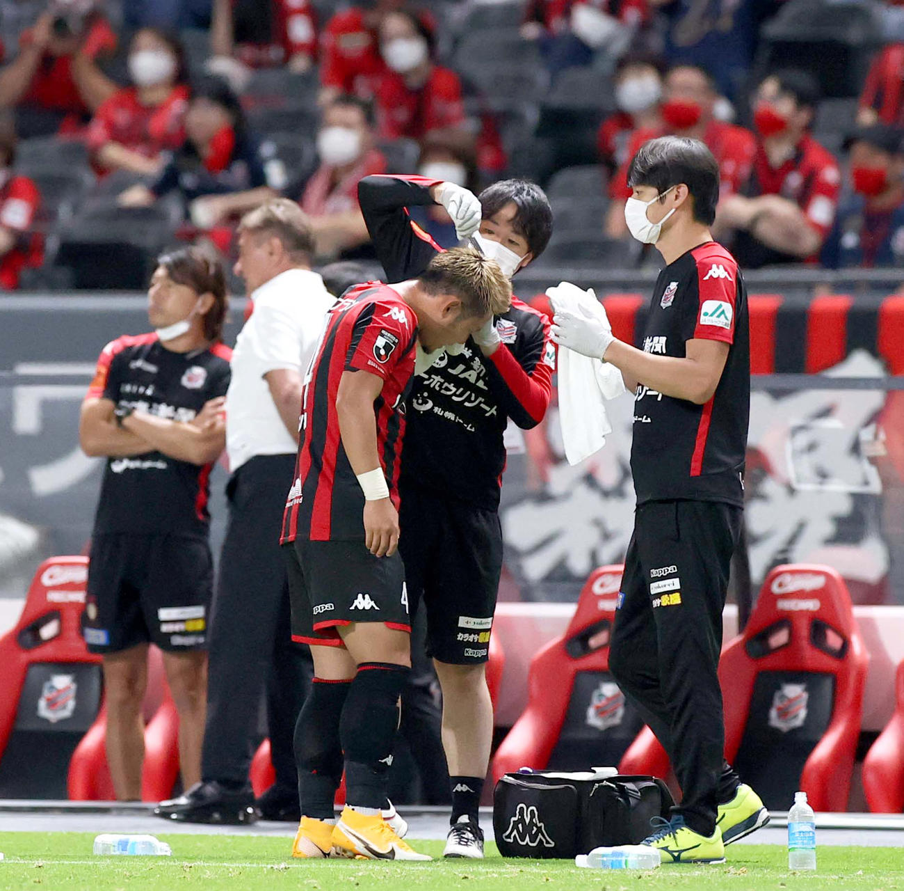 競り合った際に頭を負傷し手当を受ける札幌MF菅（撮影・佐藤翔太）