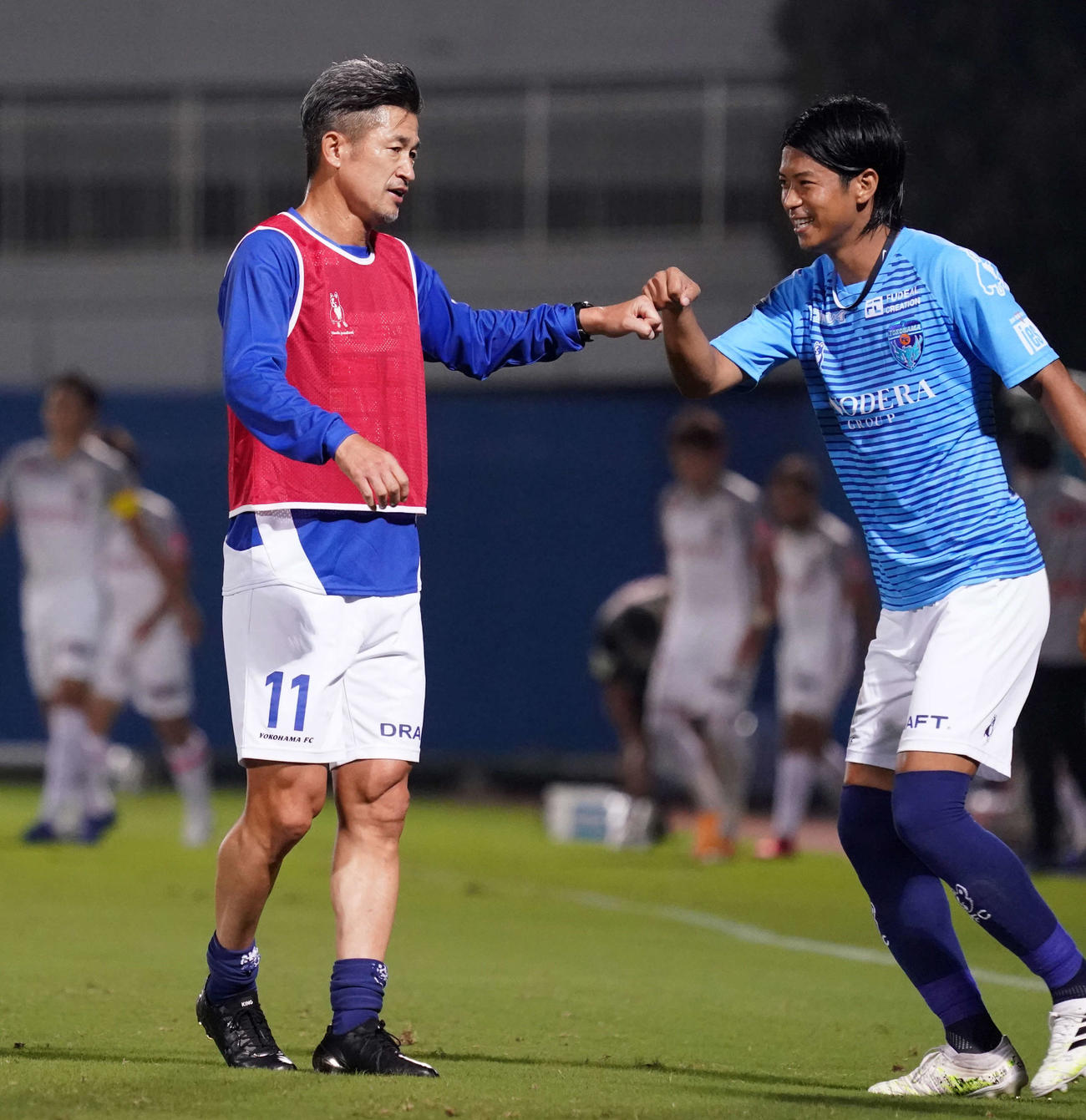 横浜FC対名古屋　後半開始前、横浜FC・DF田代（右）とタッチをかわすFWカズ（撮影・江口和貴）