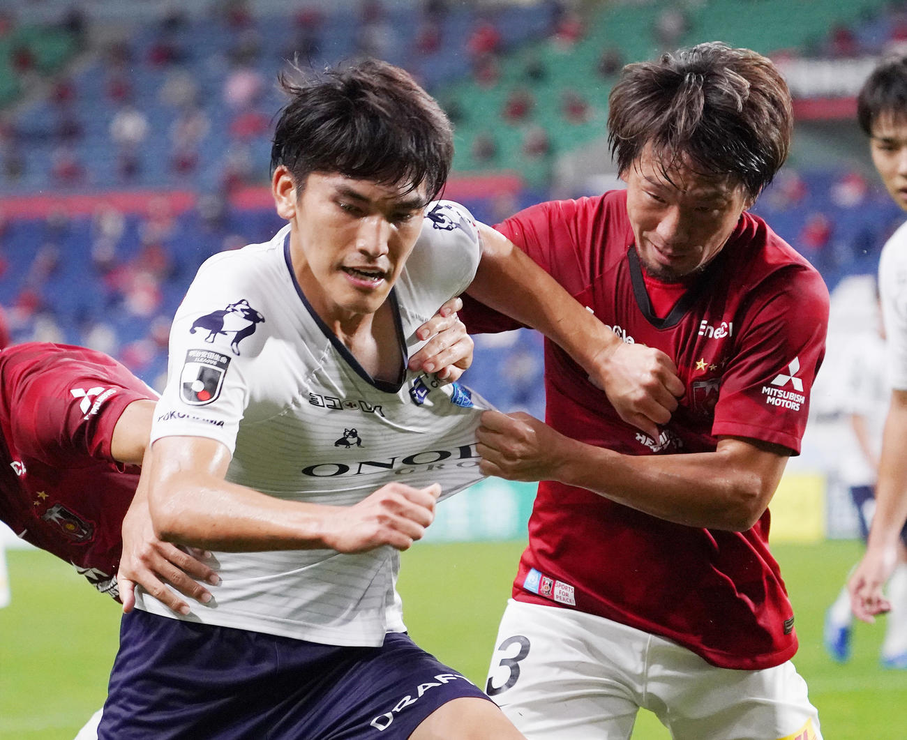 浦和対横浜FC　後半、浦和DF宇賀神（右）と激しく競り合う横浜FC・FW一美（撮影・菅敏）