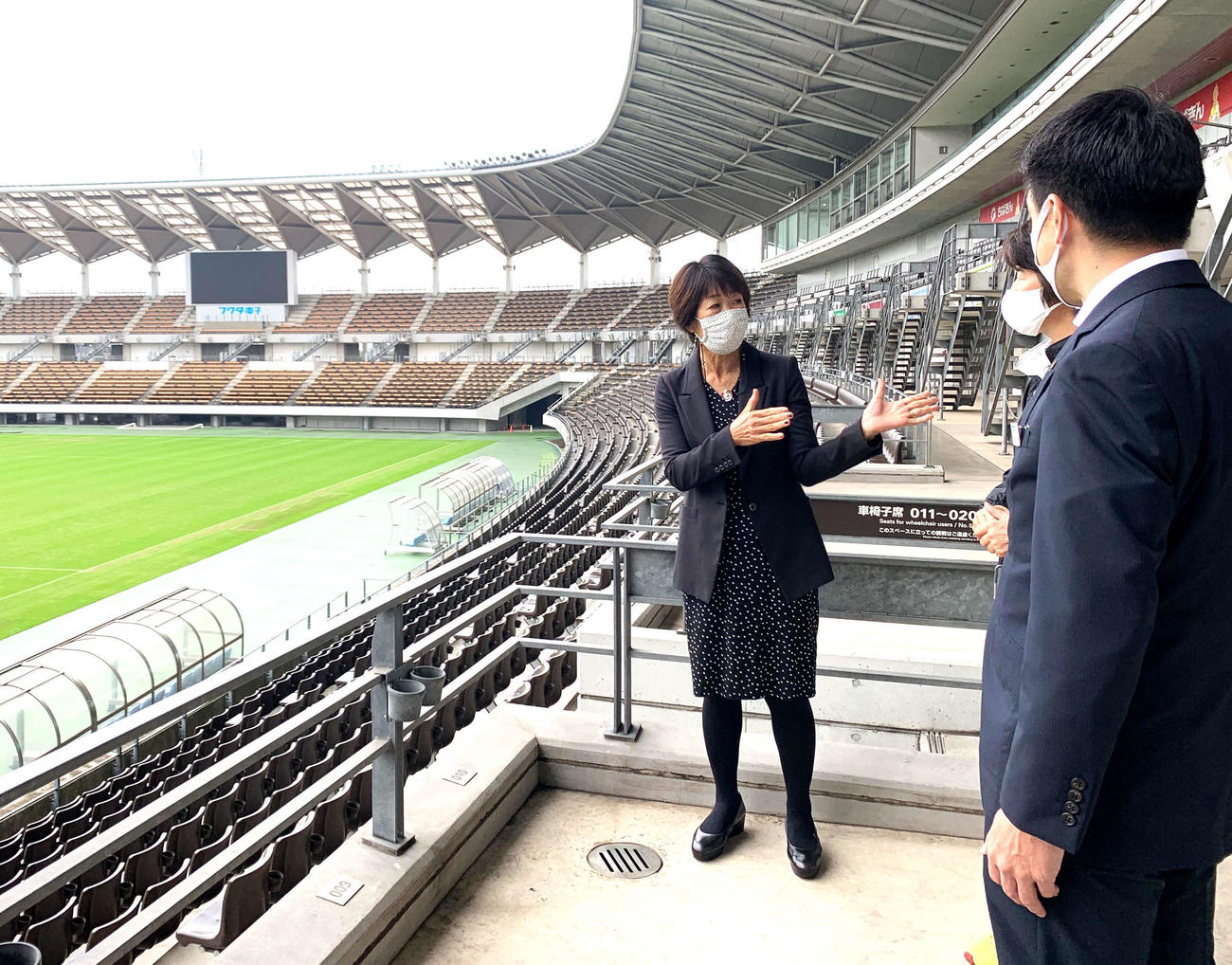 スタジアムで説明を受けるWEリーグの岡島チェア（左端）