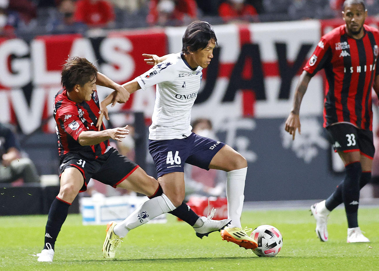 札幌―横浜FC　後半、競り合う横浜FC・中村（46）と札幌・高嶺（共同）
