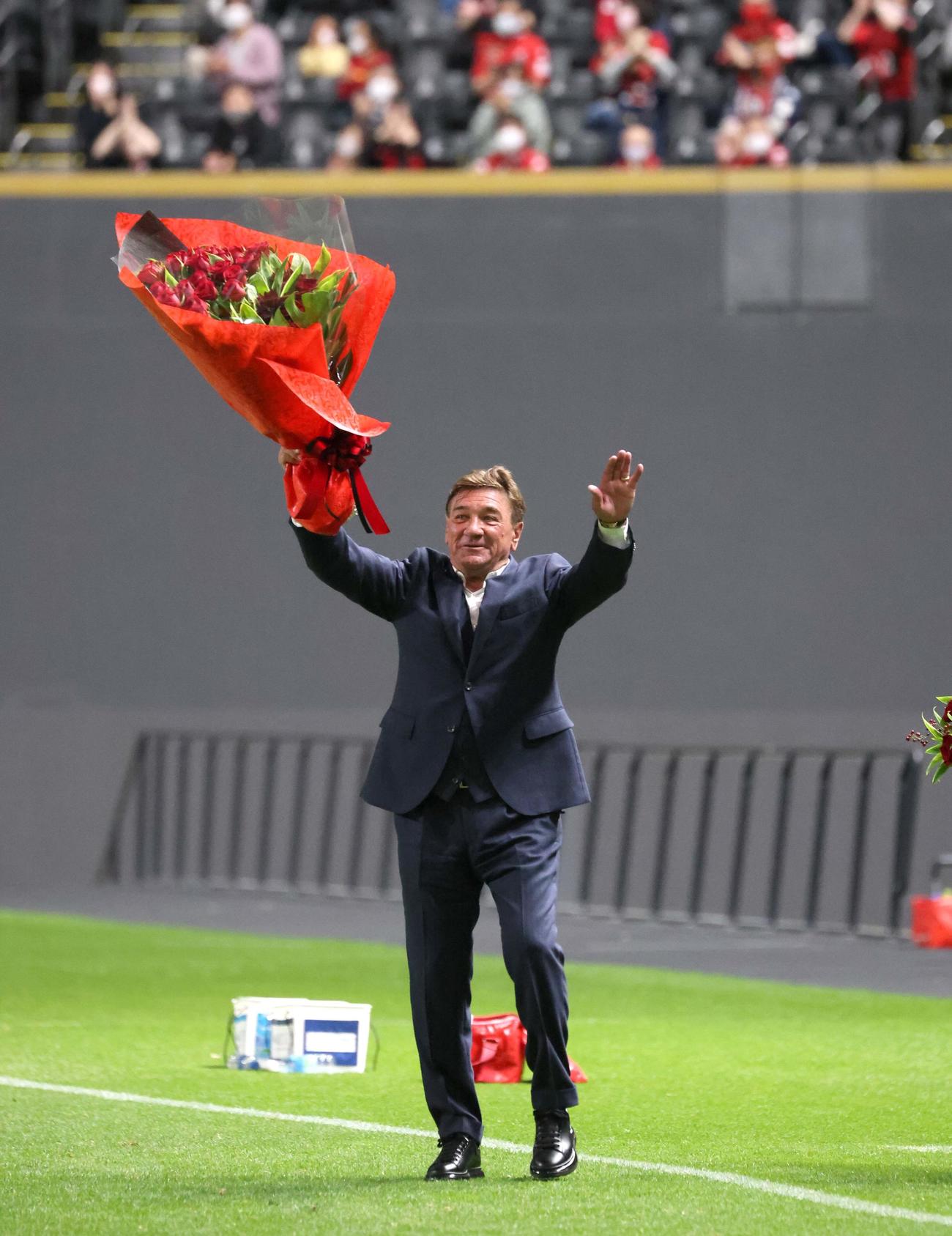 札幌対横浜FC　試合後、スタンドに向かって花束を掲げるペトロビッチ監督（撮影・黒川智章）