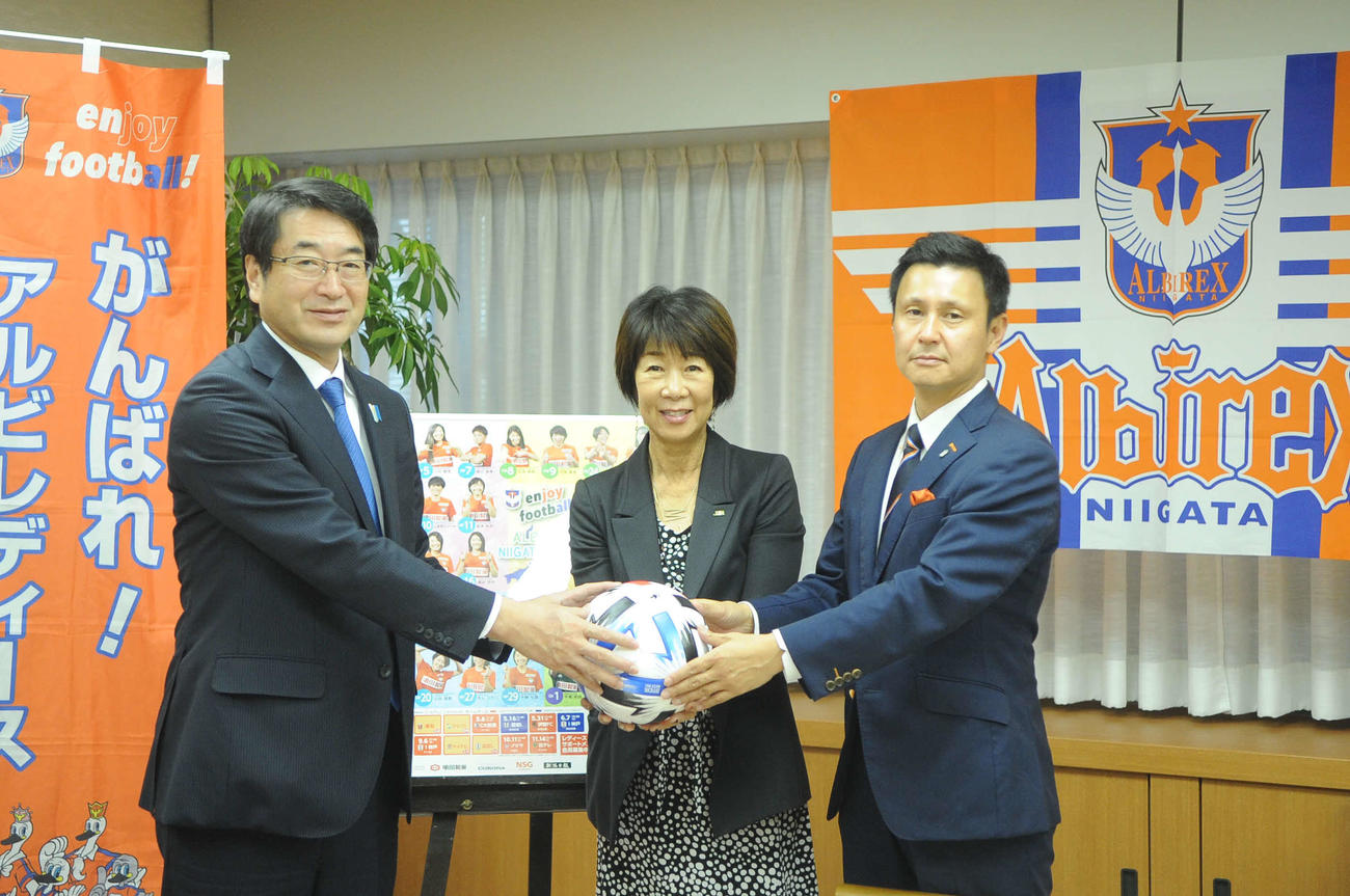 新潟市の中原市長（左）にボールを手渡す岡島理事長（中央）と新潟L山本社長