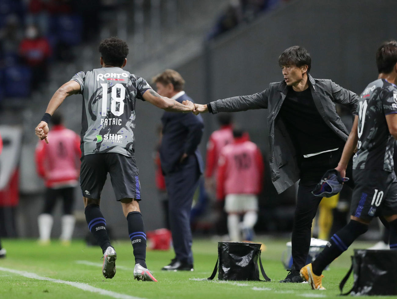 G大阪対札幌　後半、勝ち越しゴールを決めたG大阪FWパトリック（左）とグータッチする宮本監督（撮影・前田充）