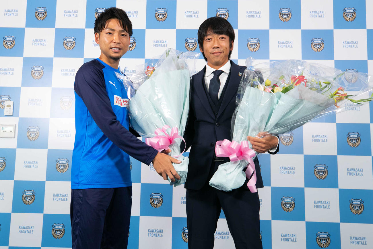 引退会見を終えてチームメートのFW小林（左）から花束を受け取る川崎F・MF中村（Ｃ）KAWASAKI　FRONTALE