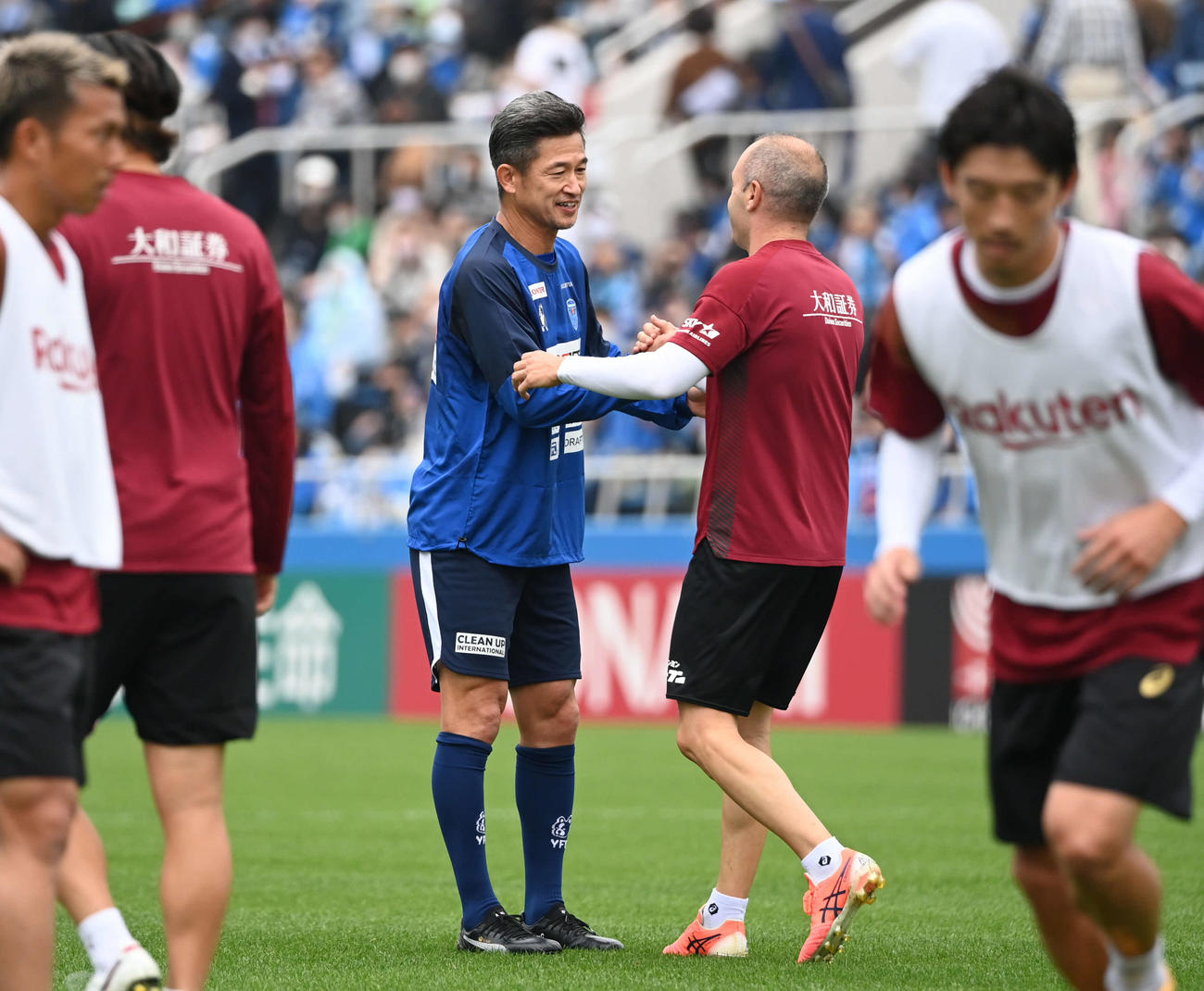 横浜FC対神戸　試合前の練習中に握手する横浜FCカズと神戸イニエスタ（撮影・山崎安昭）