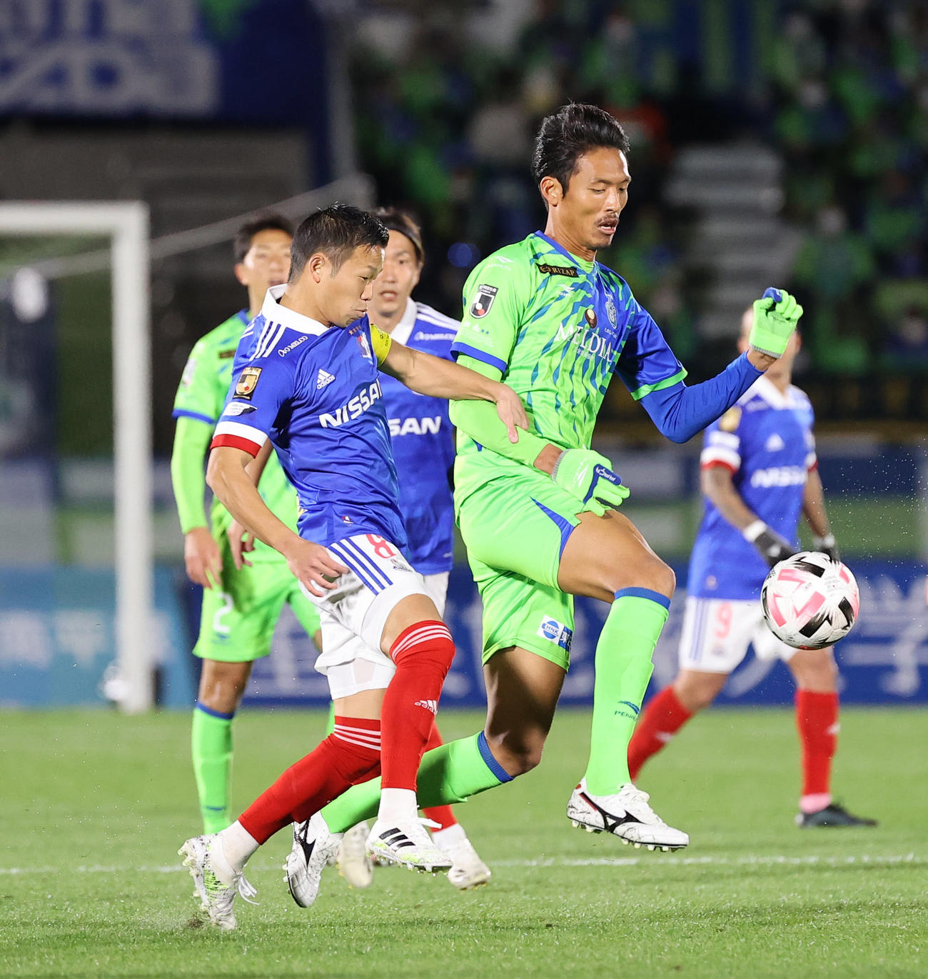 湘南対横浜　前半、競り合う湘南FW指宿（右）と横浜MF喜田（撮影・垰建太）