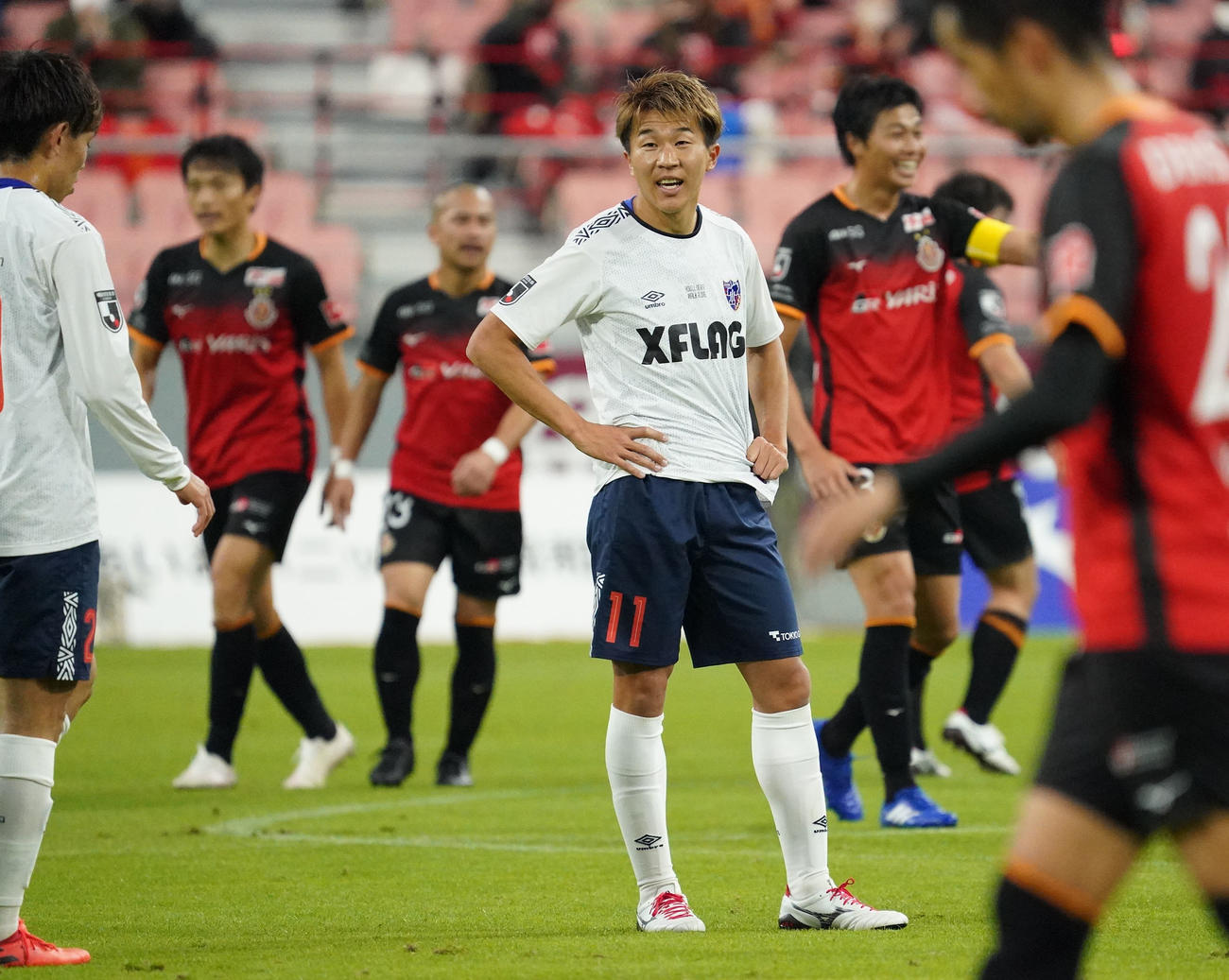 試合終了、勝利に喜ぶ名古屋イレブンと対照的にさえない表情の東京FW永井謙佑（撮影・森本幸一）