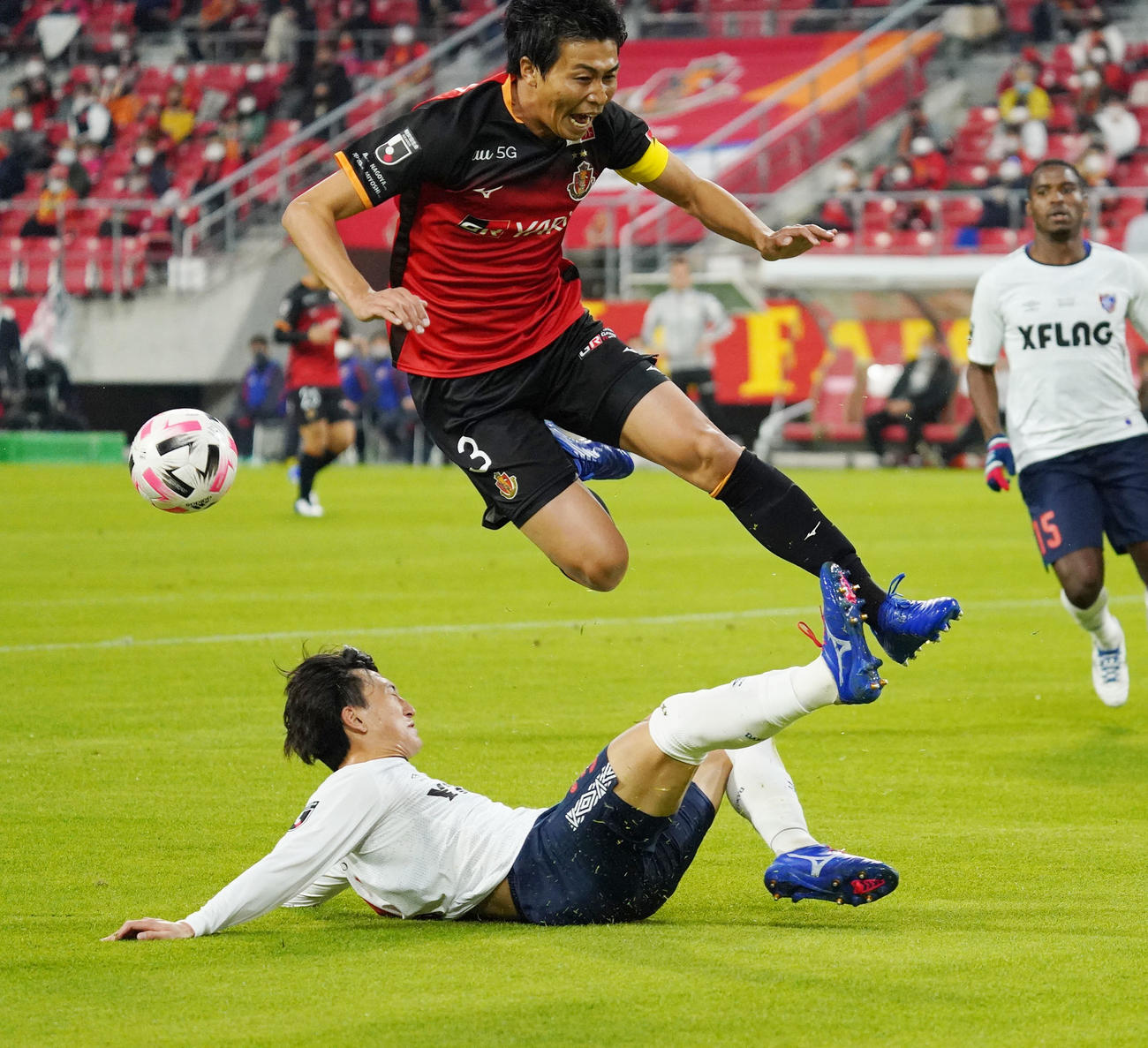 前半、名古屋DF丸山祐市（上）と競り合うFC東京DF中村帆高（下）（撮影・森本幸一）