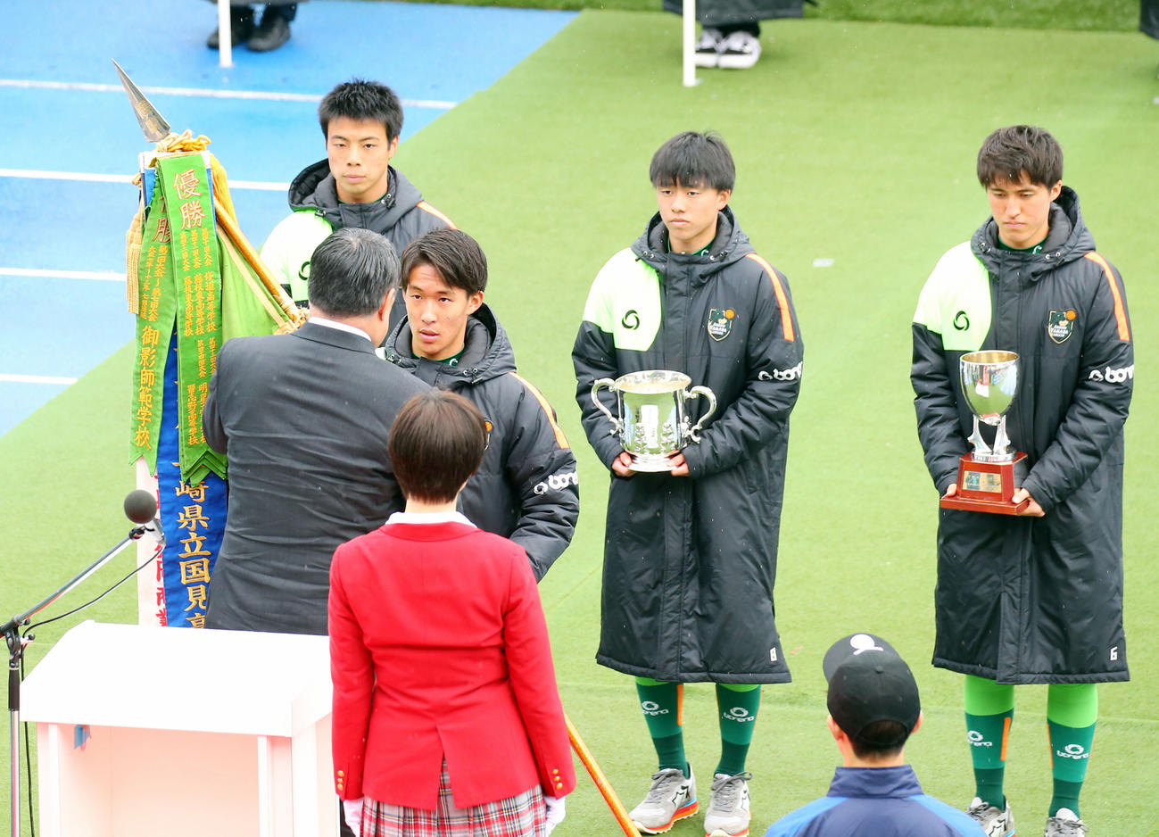 昨年の全国高校サッカー開会式で優勝旗とトロフィーを返還する青森山田・武田英寿（手前右）ら（2019年12月30日撮影）