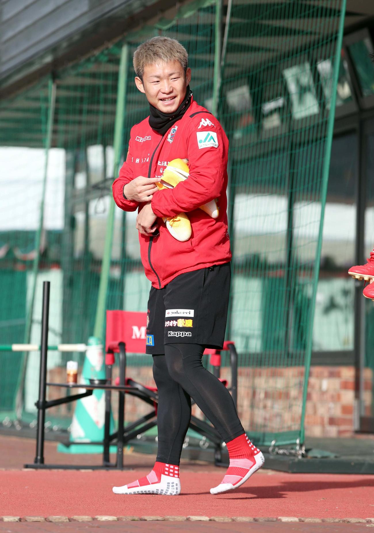 笑顔でグラウンド入りする札幌FW菅（撮影・佐藤翔太）