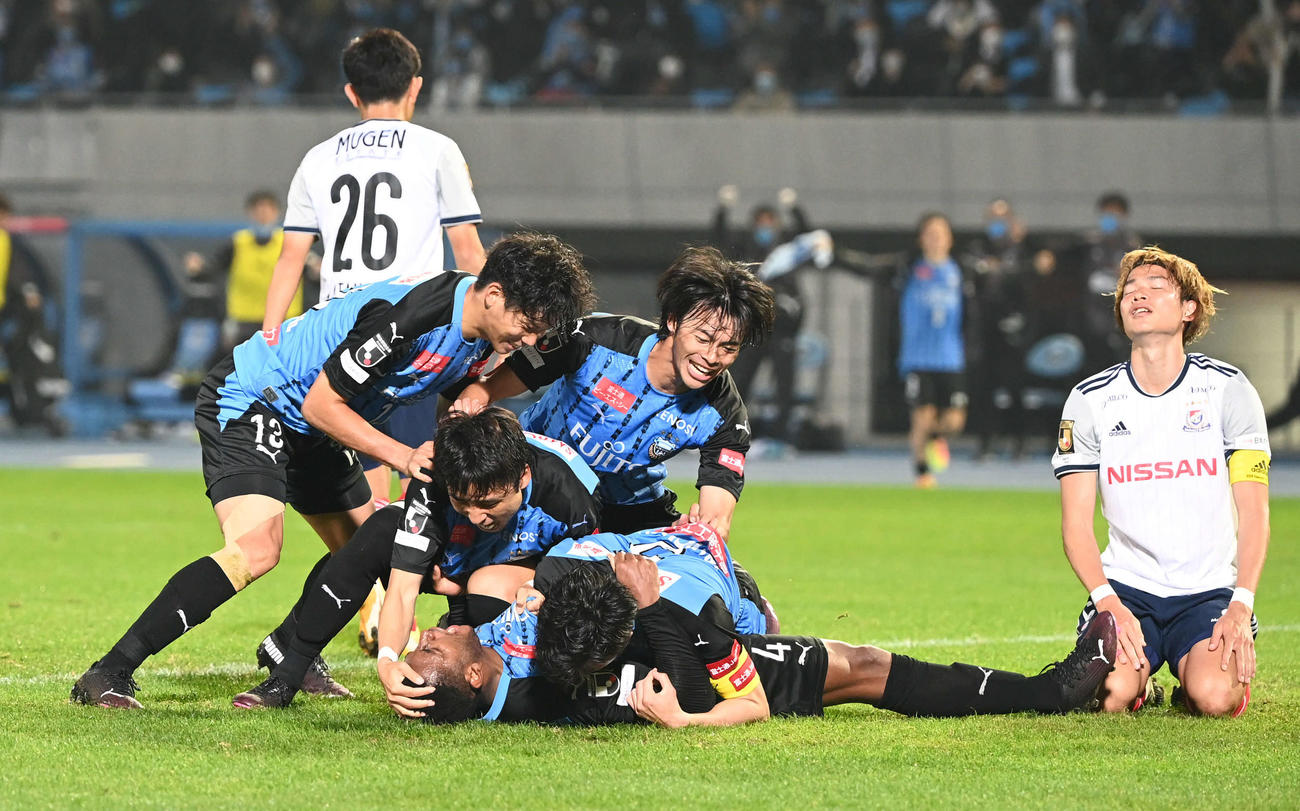 川崎F対横浜　後半、勝ち越し点を決めた川崎F・DFジェジエウ（下）を三笘（中央）らチームメートは手荒く祝福する。右は横浜MF扇原（撮影・山崎安昭）