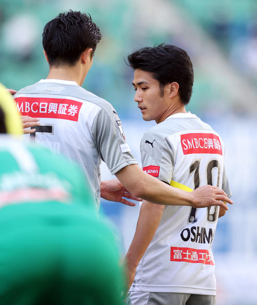 大分対川崎F　前半、一発レッドで退場した川崎F・DF谷口（左）からキャプテンマークを巻いてもらうMF大島（撮影・狩俣裕三）