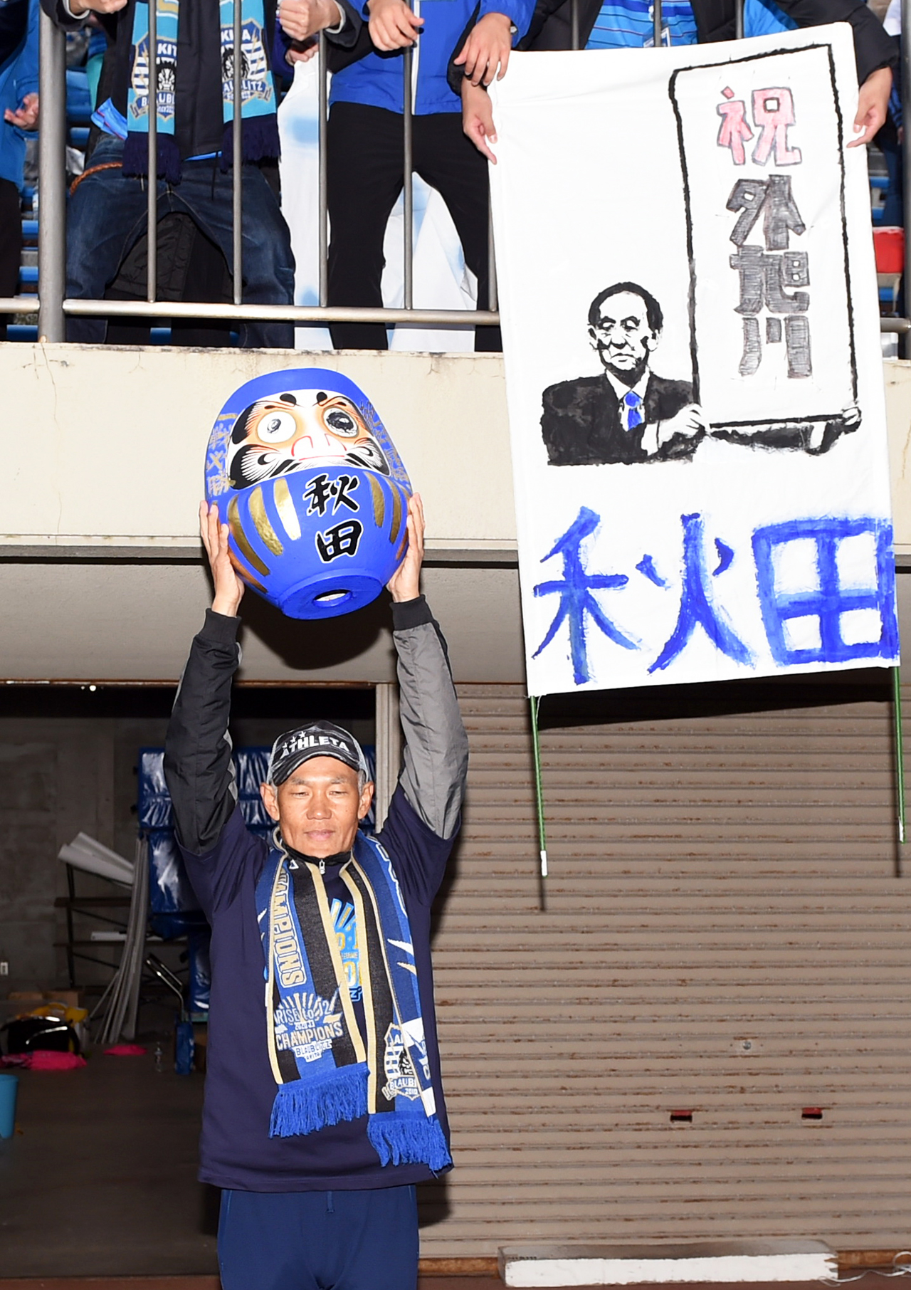 目入れしただるまを掲げる秋田吉田監督（撮影・山田愛斗）
