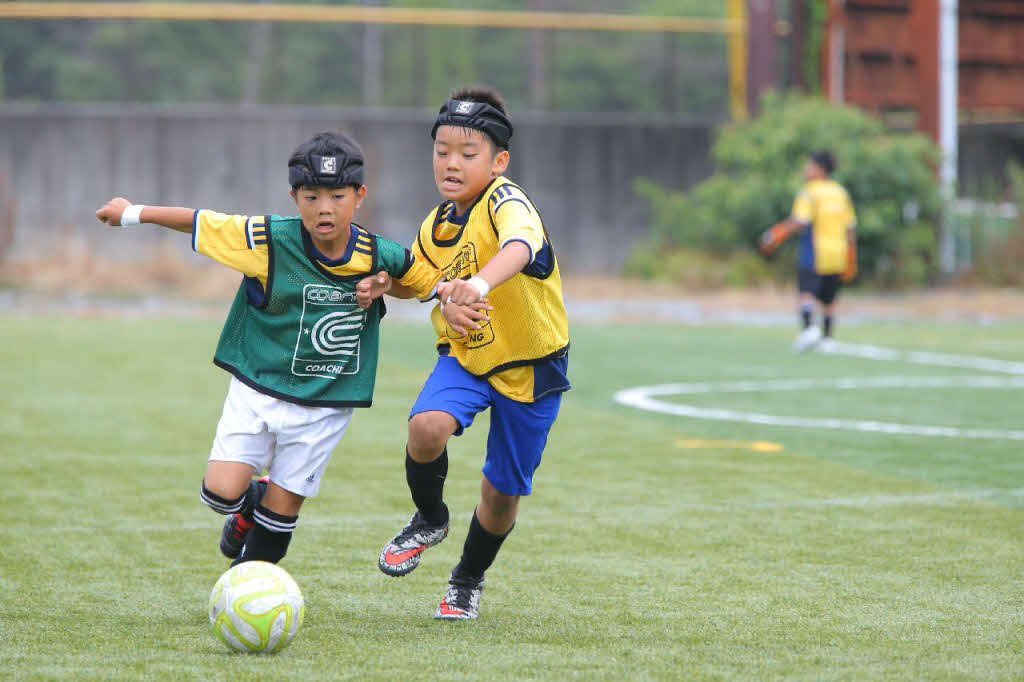 ヘッドガードをつけてプレーする子どもたち（クーバー・コーチング・ジャパン提供）