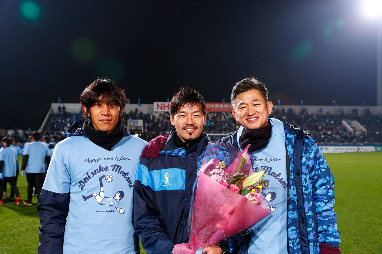 花束を持ち写真に納まる横浜FC・MF松井（中央）。左はMF中村、右はFW三浦（C）・YOKOHAMA　FC