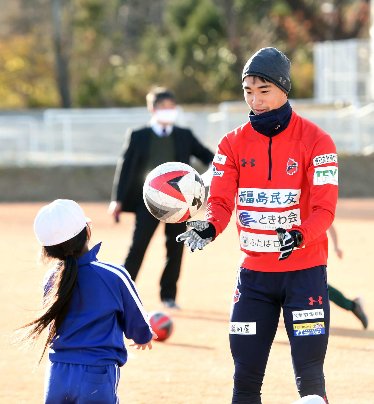 小学生にボールをわたすいわきFC・MF寺村（撮影・相沢孔志）