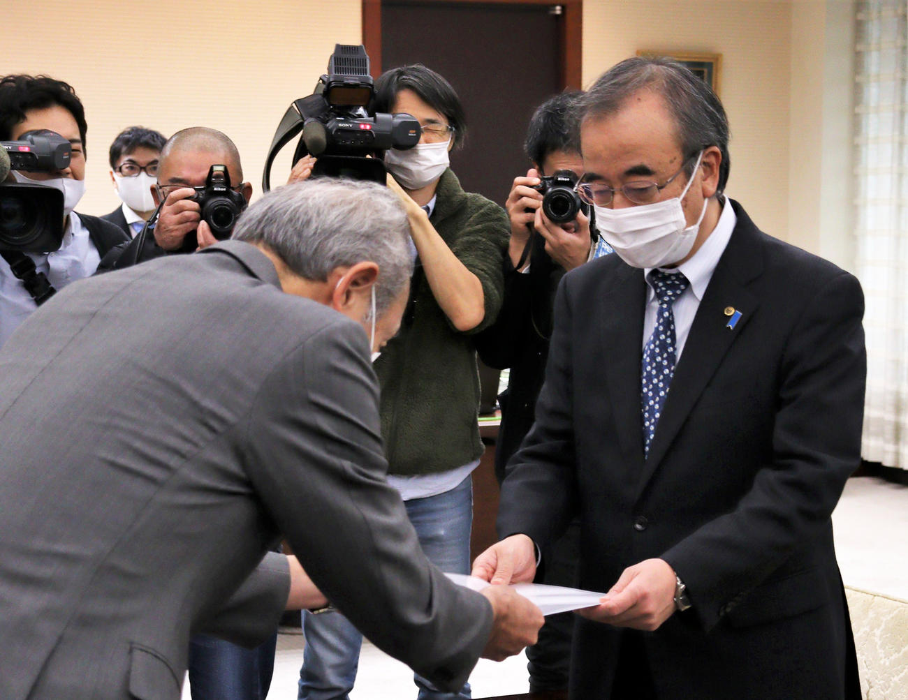 前所属選手の道路交通法違反についての報告書を花角知事（右）に手渡す中野社長（撮影・飯嶋聡美）