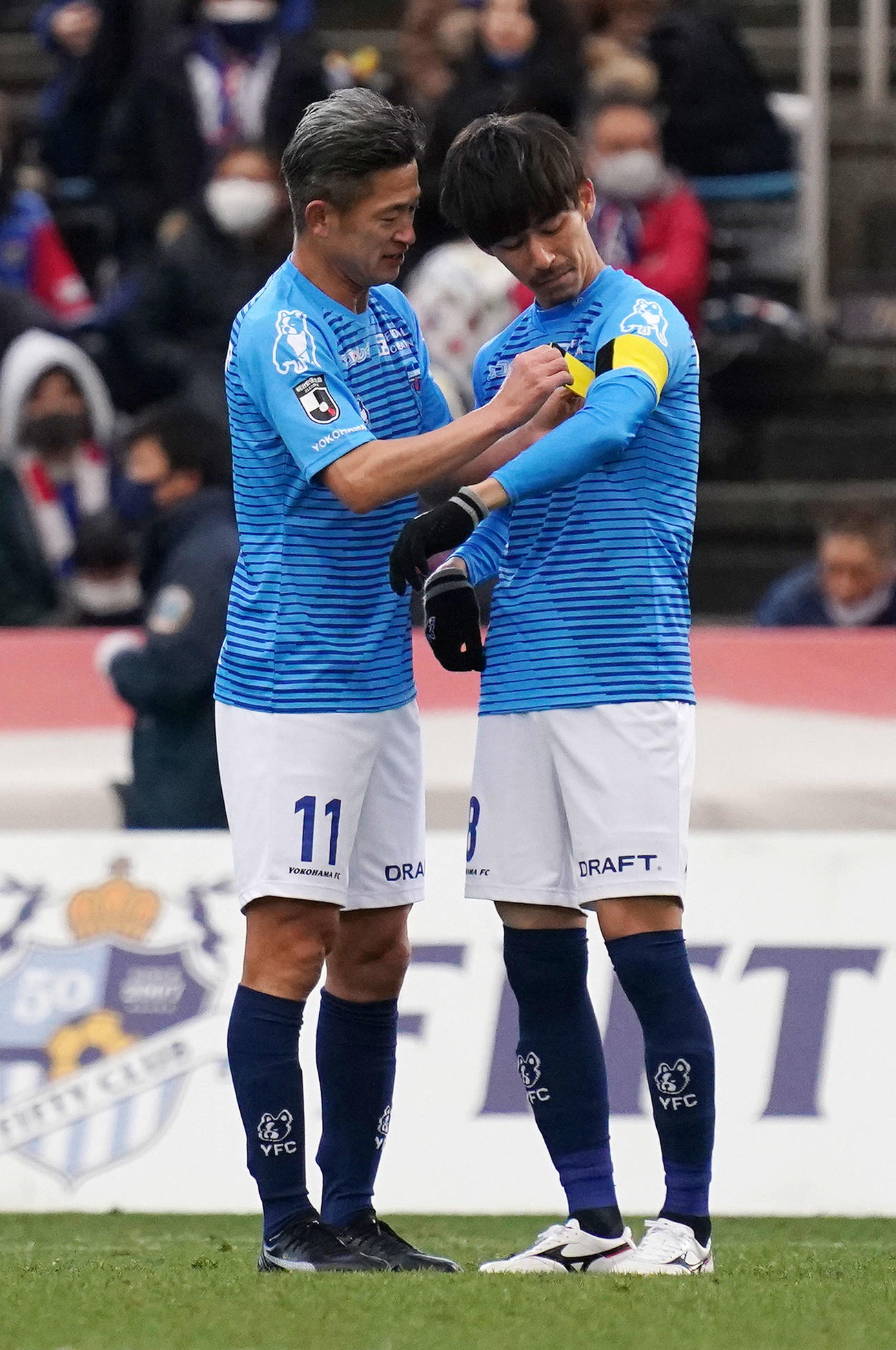 横浜FC対横浜　試合後、横浜FC・MF佐藤（右）に主将マークを巻くFWカズ（撮影・江口和貴）