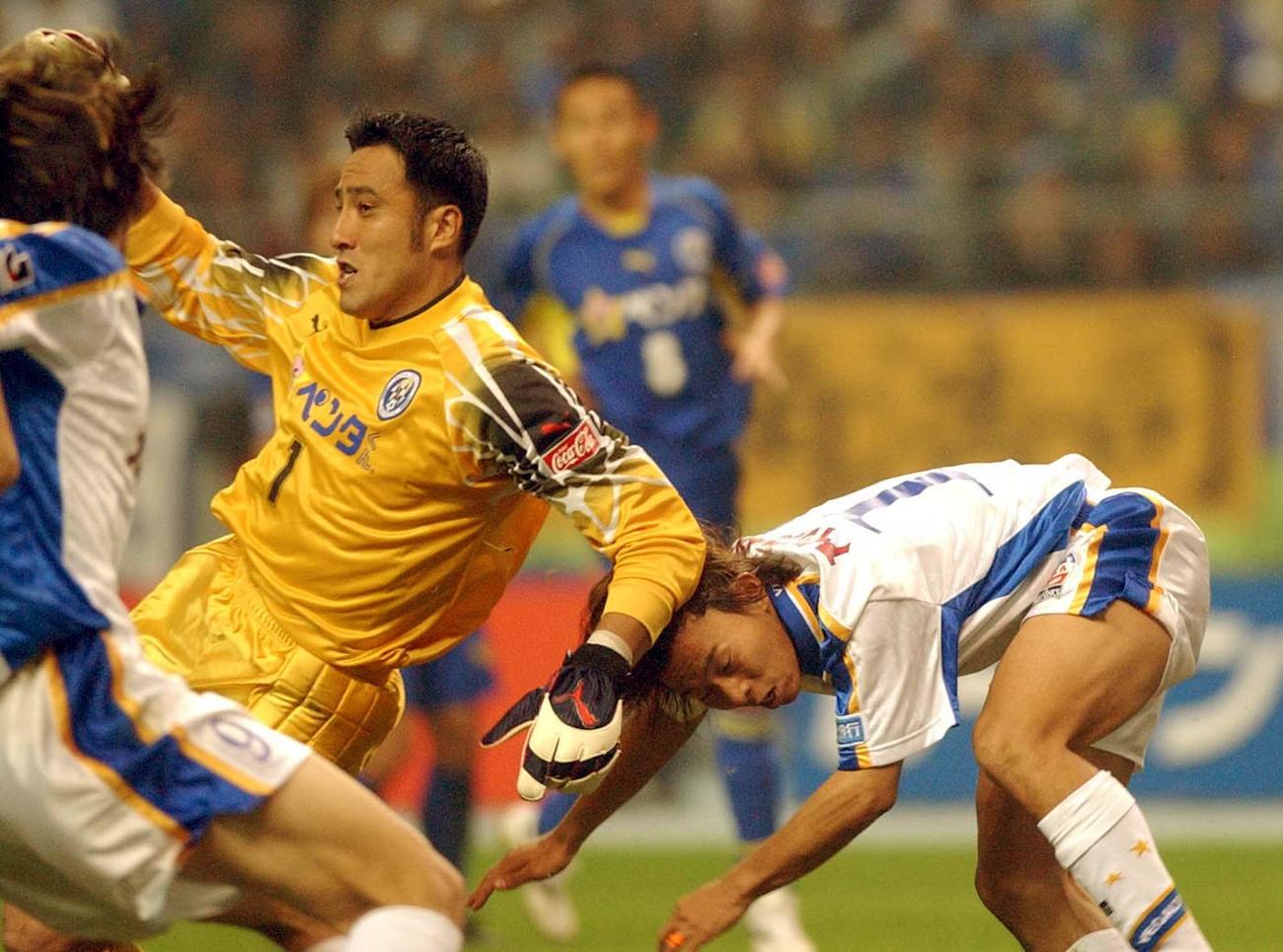 大分対仙台　後半21分、大分GK岡中勇人（左）ともつれ合い転倒する仙台FW佐藤寿人（2003年11月29日撮影）