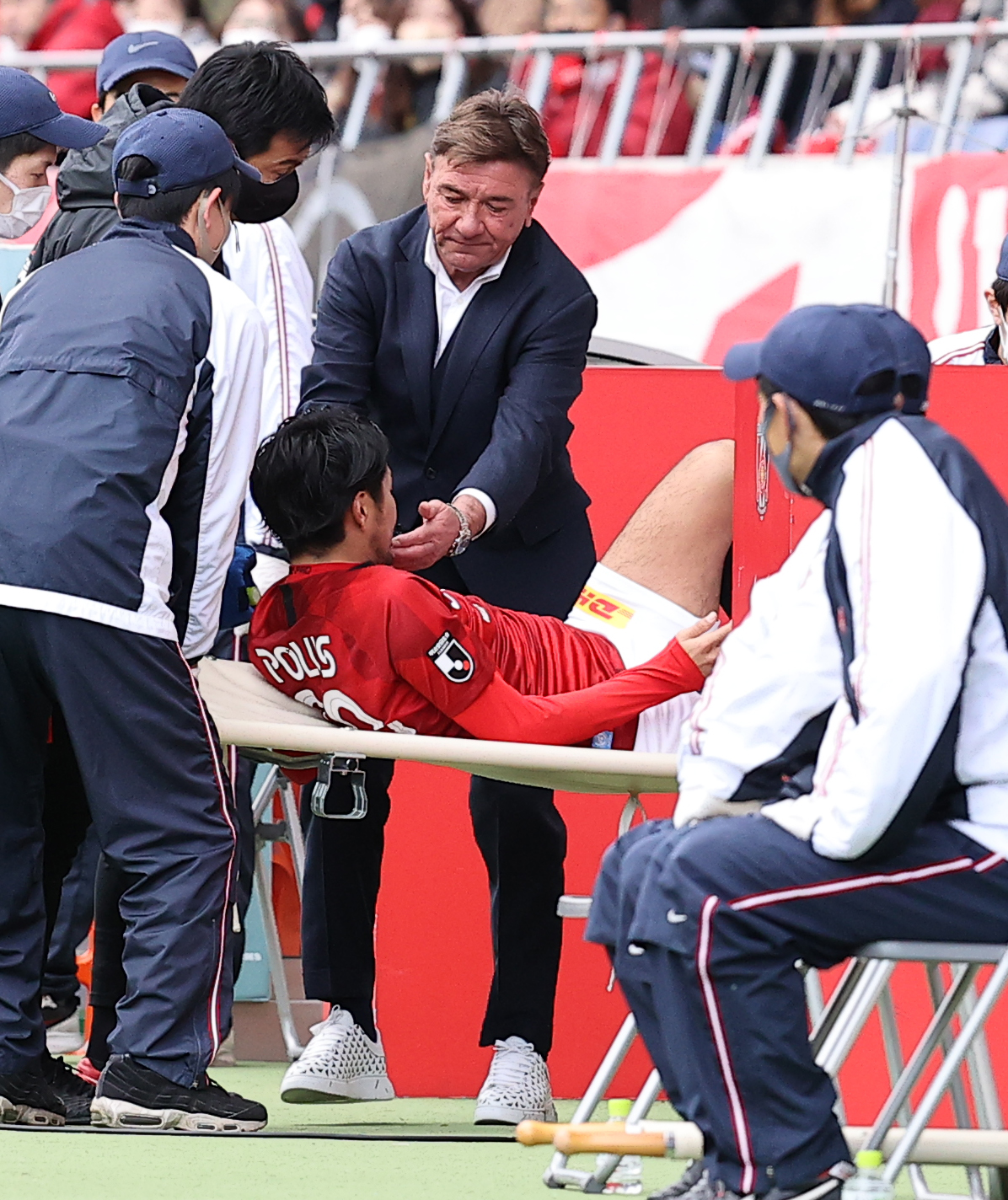 最終節札幌戦の前半、負傷して担架で運ばれる浦和FW興梠に声をかける札幌のペトロビッチ監督（2020年12月19日撮影）
