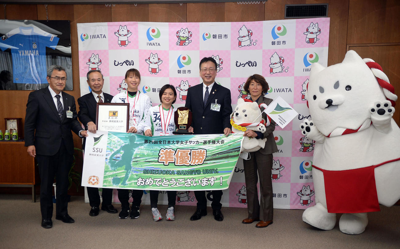 表敬訪問後に記念撮影する、左から磐田市の村松教育長、同市スポーツ協会の河島会長、静岡産大DF彦坂、静岡産大FW藤田、磐田市の渡部市長、静岡産大の本田監督