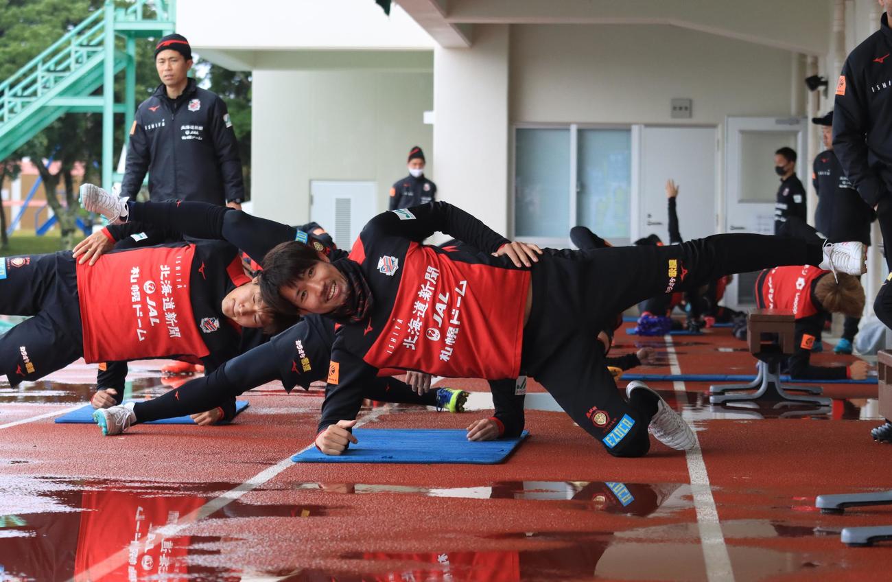 体幹トレーニング中にカメラに笑顔を見せる札幌DF柳（撮影・保坂果那）