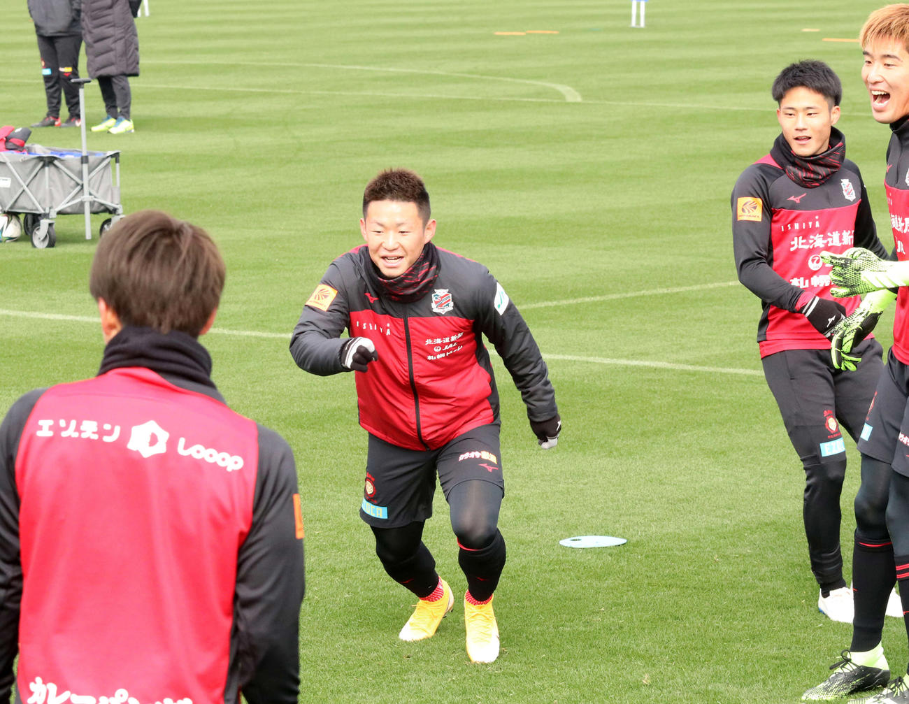 ボール回しで笑顔でボールを追いかける札幌FW菅（左から2人目）（撮影・浅水友輝）
