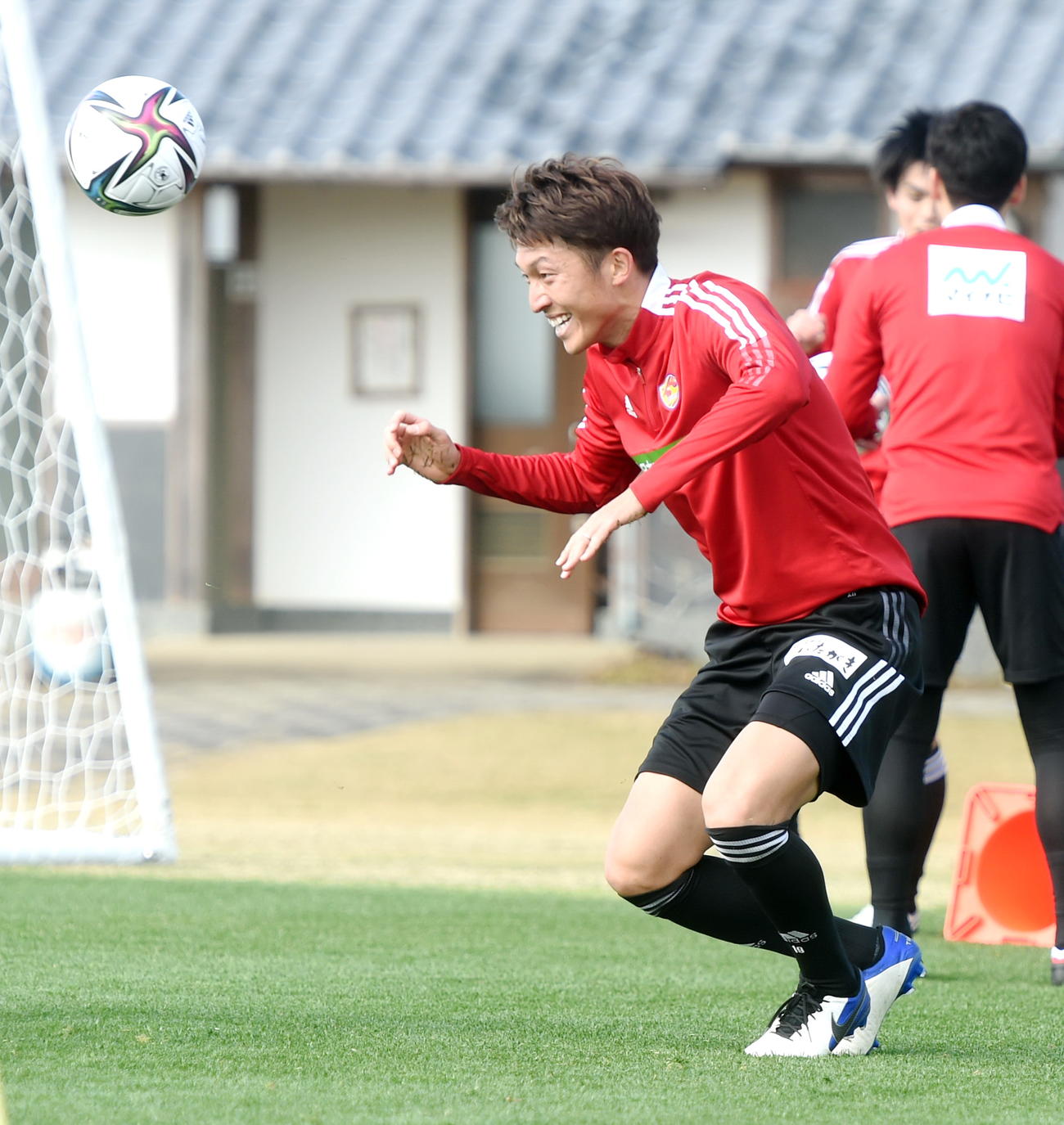 笑顔でヘディングする皆川