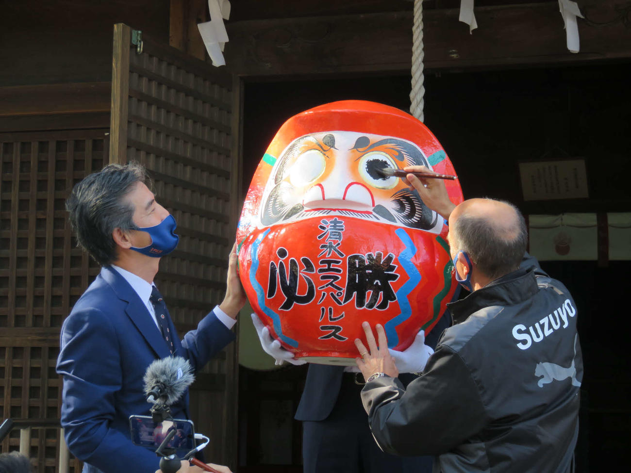 静岡市内の神社を訪れた清水エスパルスのロティーナ監督（右）と山室晋也社長は、必勝ダルマに墨入れを行う