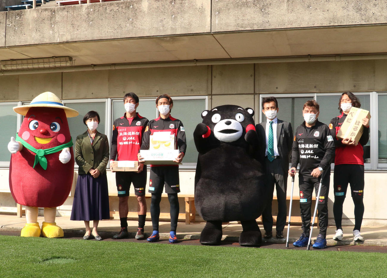 練習前に札幌のキャンプに訪れたくまモンと記念撮影する札幌の選手ら（撮影・浅水友輝）