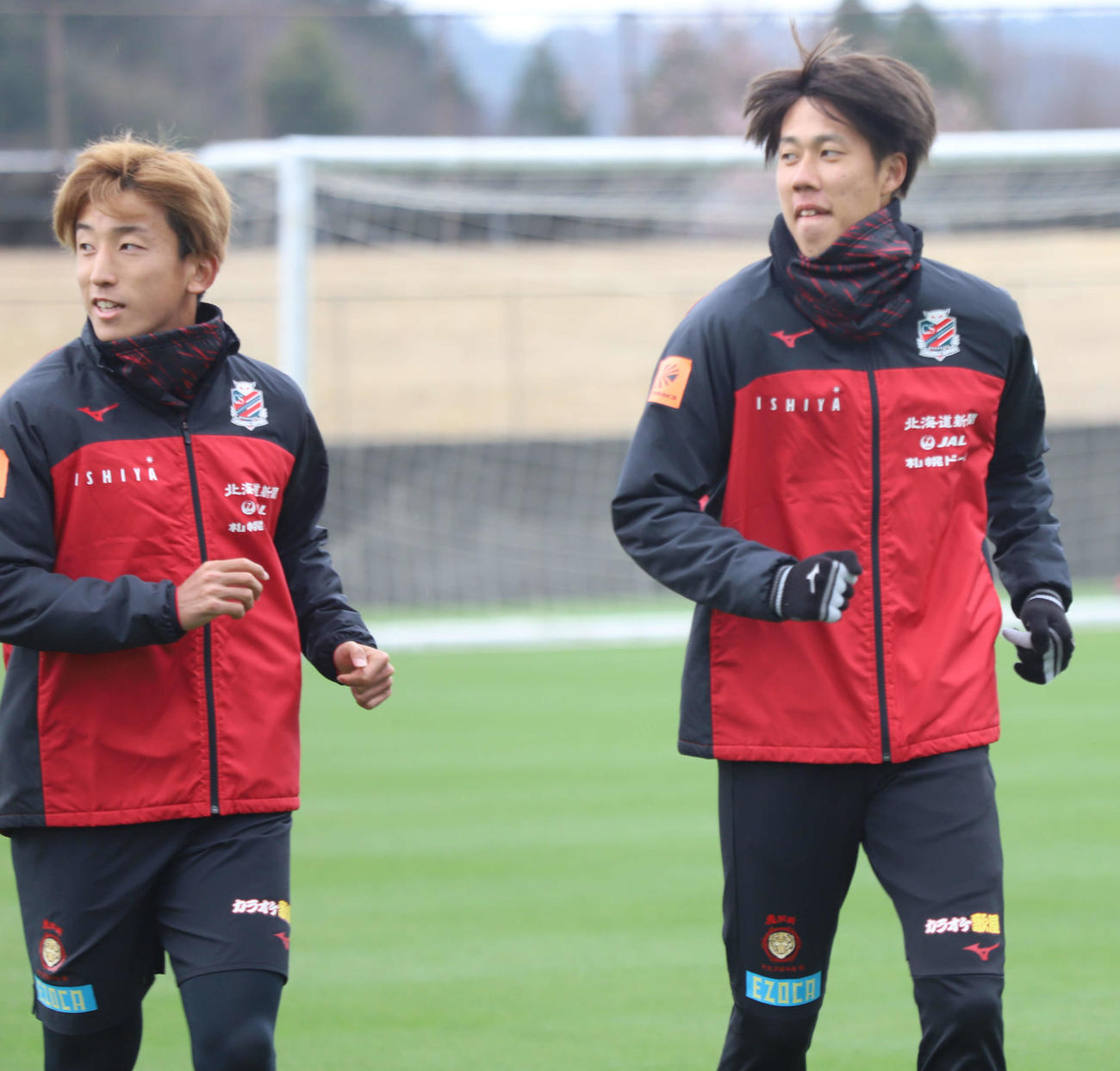 笑顔でランニングする札幌DF田中（右）。左はMF金子（c）2021 CONSADOLE